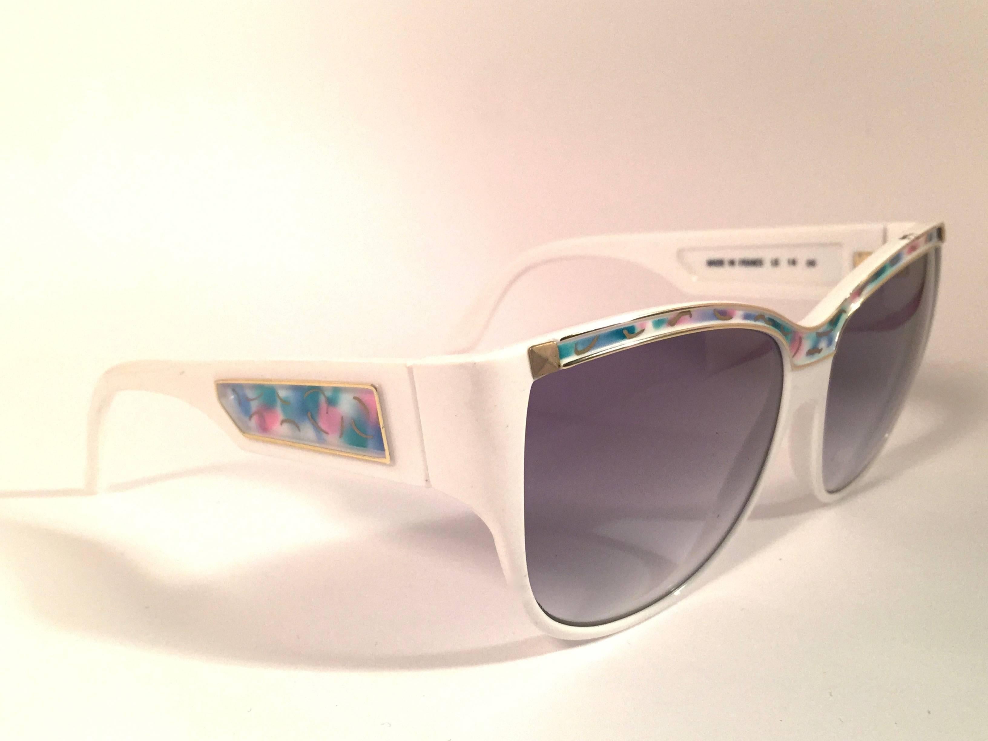 Rare pair of New vintage Leonard sunglasses. 

White with signature colours mosaic with gold accents frame holding a pair of rose gradient lenses.

New, never worn or displayed. Made in France.
