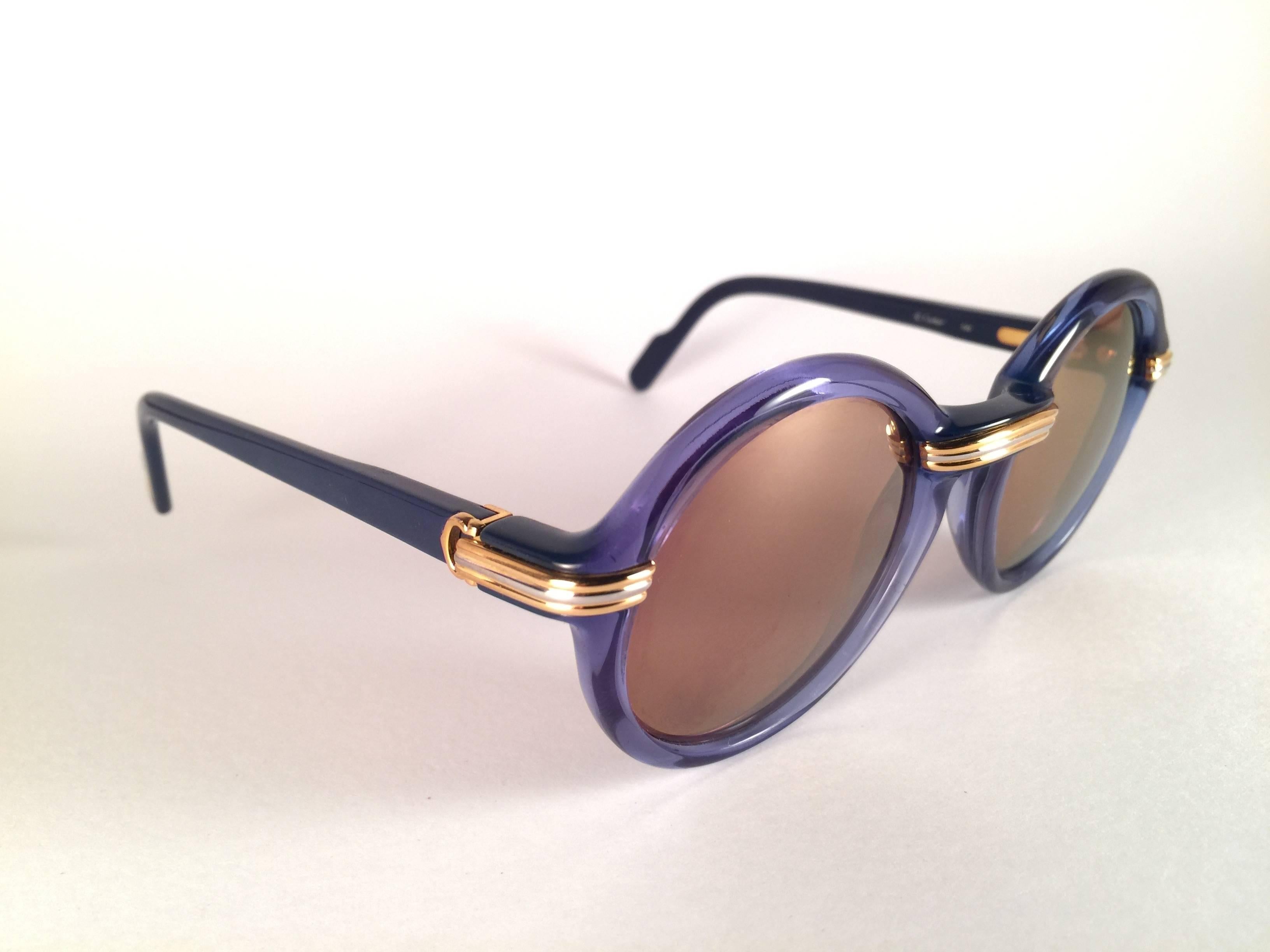 
New 1991 Original Cartier Cabriolet Art Deco Translucent Blue sunglasses G15 Gold Mirror ( uv protection ) lenses. Frame has the famous real gold and white gold accents in the middle and on the sides.  All hallmarks. Cartier gold signs on the
