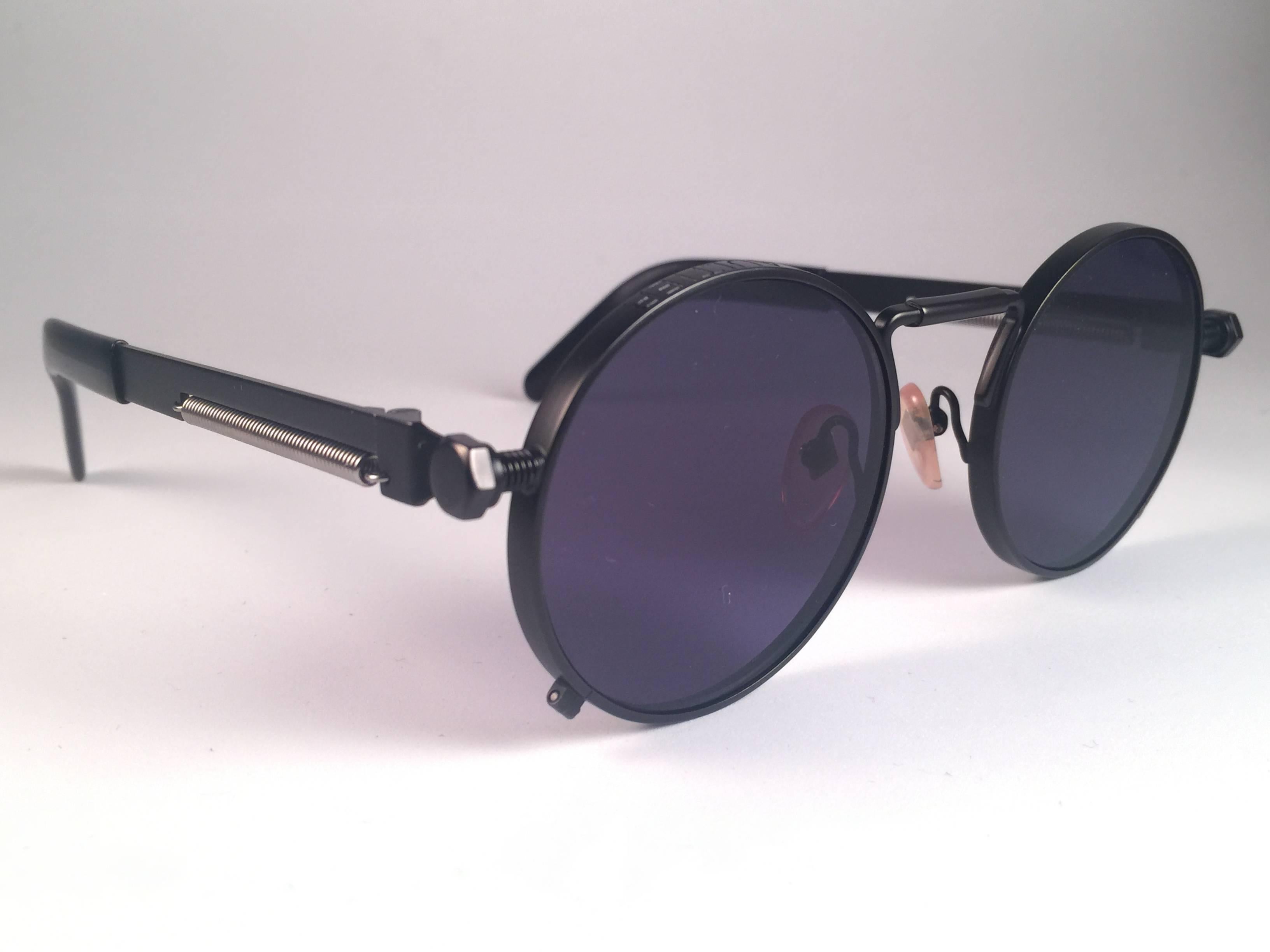 New Jean Paul Gaultier 56 8171 round black matte frame.  Flat dark purple lenses that complete a ready to wear JPG look.  Amazing design with strong yet intricate details. Design and produced in the 1900's. New, never worn or displayed. A true