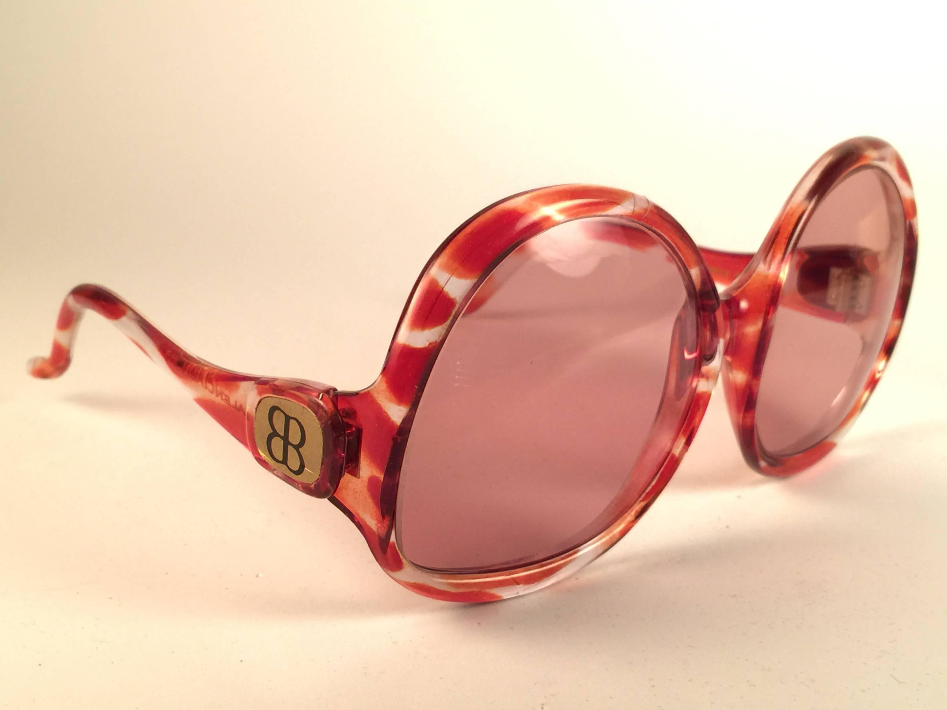 New Vintage Balenciaga clear and amber oversized frame holding a spotless pair of light rose lenses.  Never worn or displayed. This pair could show minor sign of wear due to storage.  Designed and produced in France.