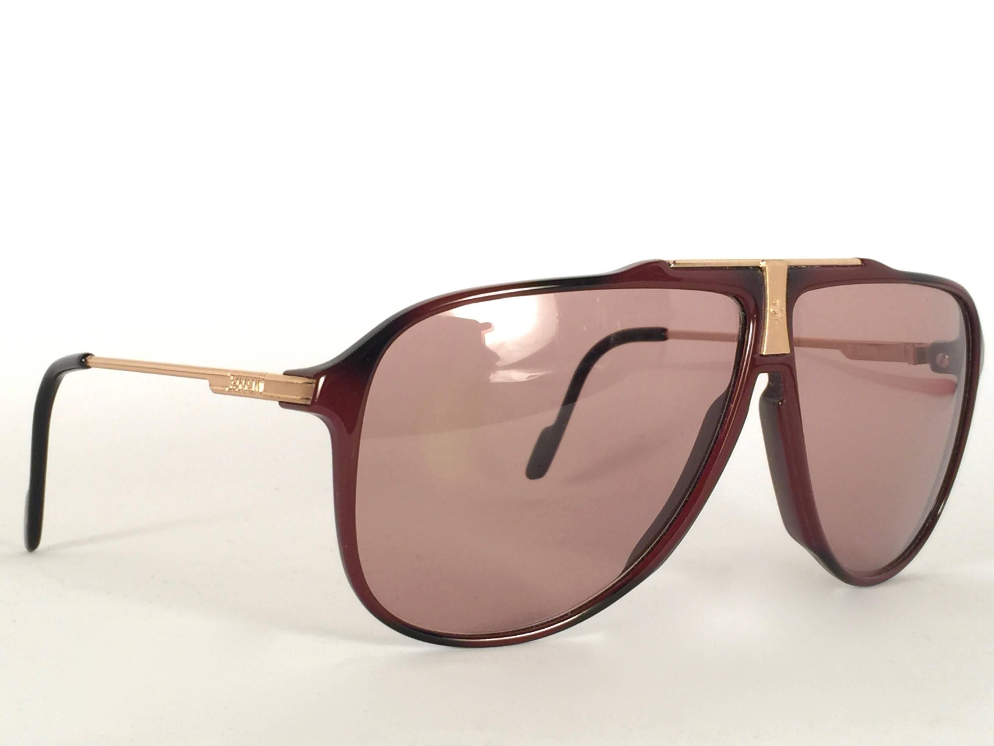 
Mint Vintage Ferrari Sunglasses bordeaux with gold accents.  

Medium brown lenses.  This item show minor sign of wear due to storage.
  
Made in Italy.