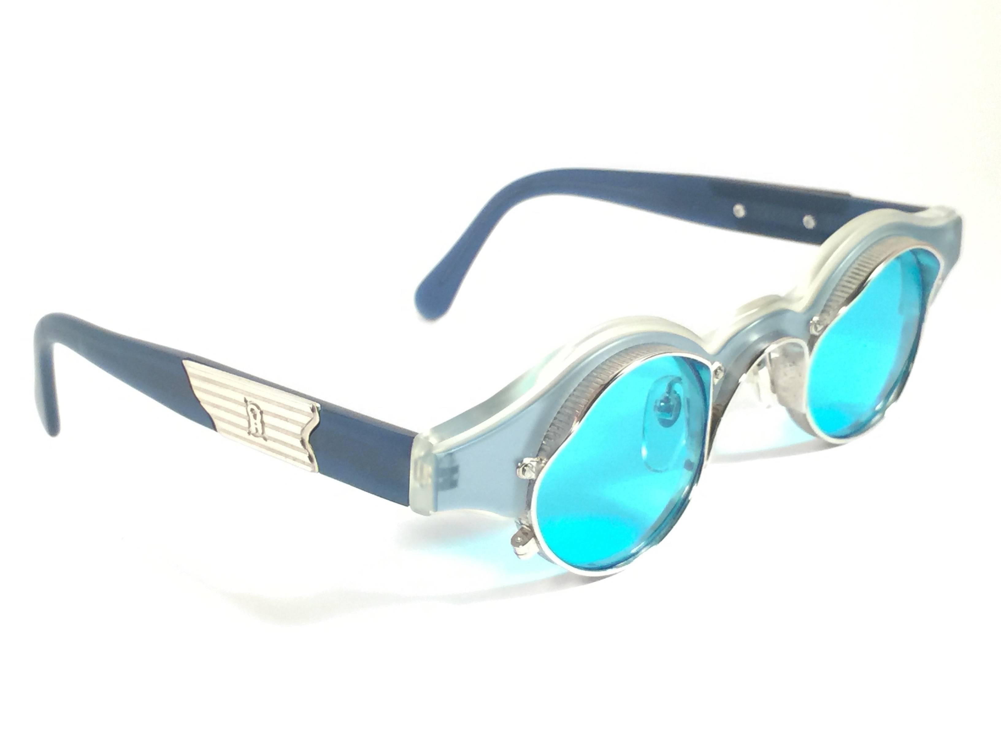 Superb. Rare new vintage made in japan Matsuda sunglasses. 

Round clear blue with silver inserts frame holding a spotless pair of light blue lenses.  

 A design and quality statement.