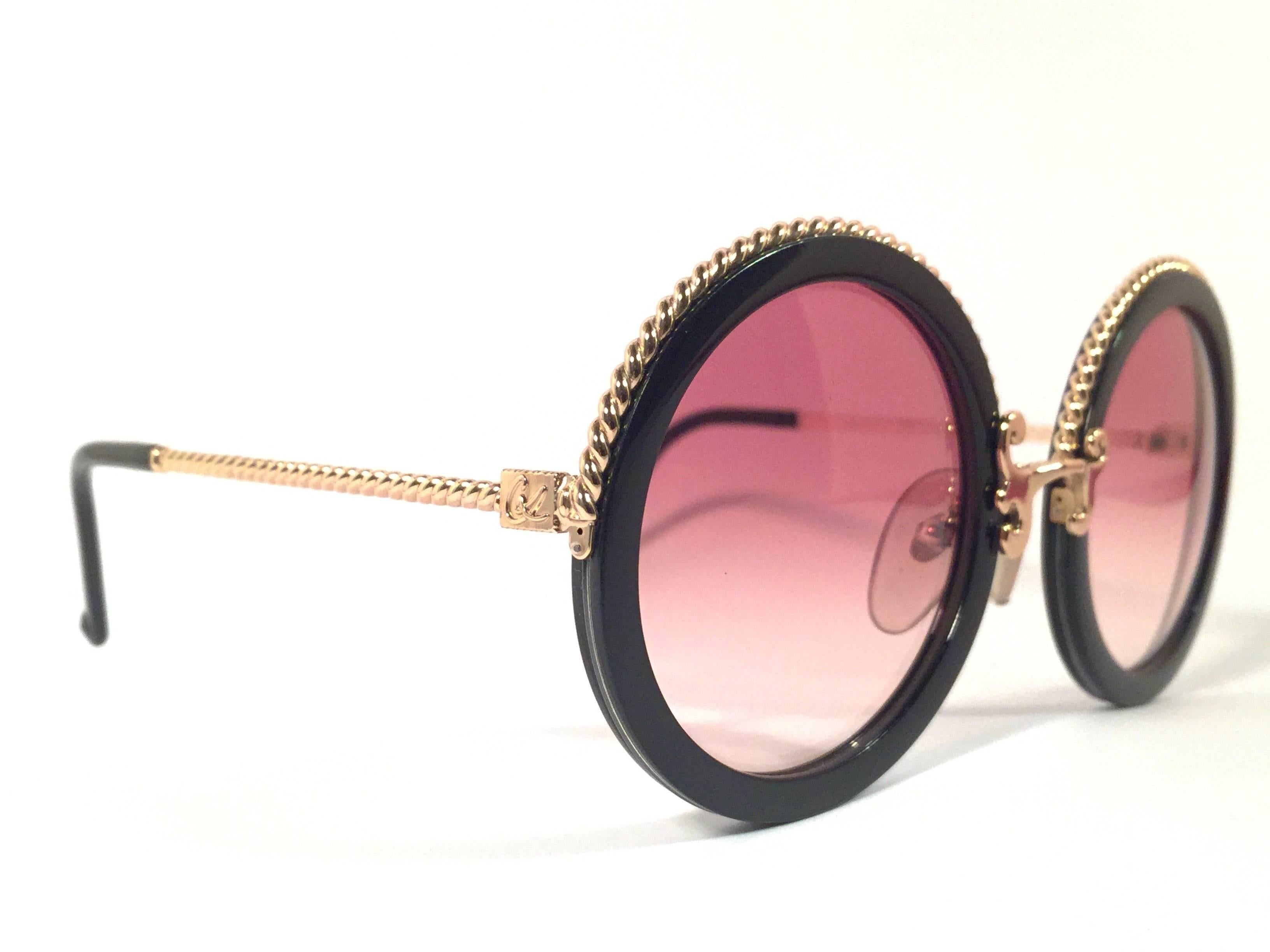 Superb & rare pair of New vintage Christian Lacroix sunglasses.   

Black with delicate gold accents frame holding a pair of spotless amber lenses.  

New, never worn or displayed. Made in France.