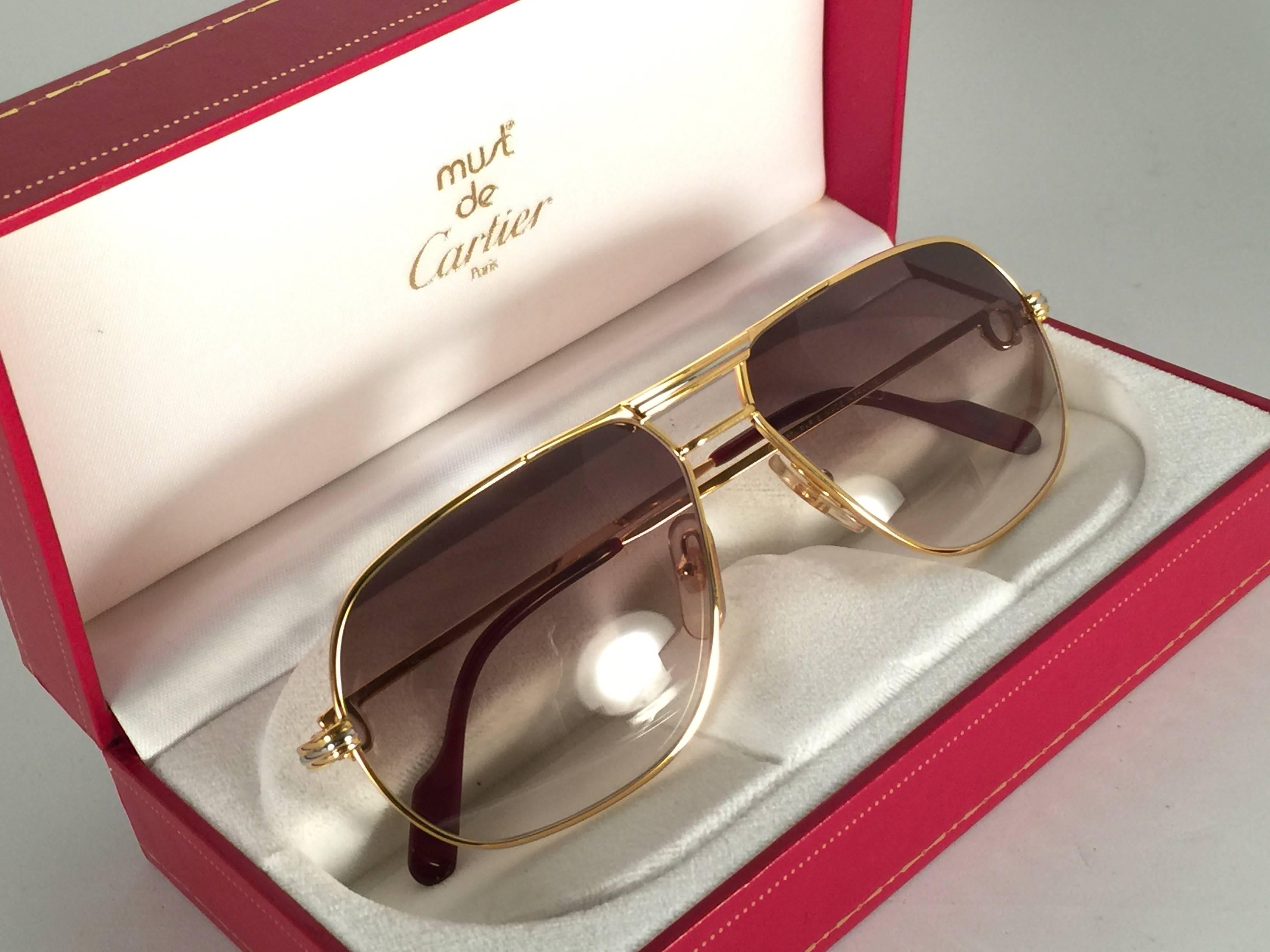 New 1988 Cartier Aviator Tank sunglasses with new honey gradient (uv protection) lenses.
Frame is with the front and sides in yellow and white gold. 
All hallmarks. Enamel with Cartier gold signs on the earpaddles. So classy, both arms sport the C