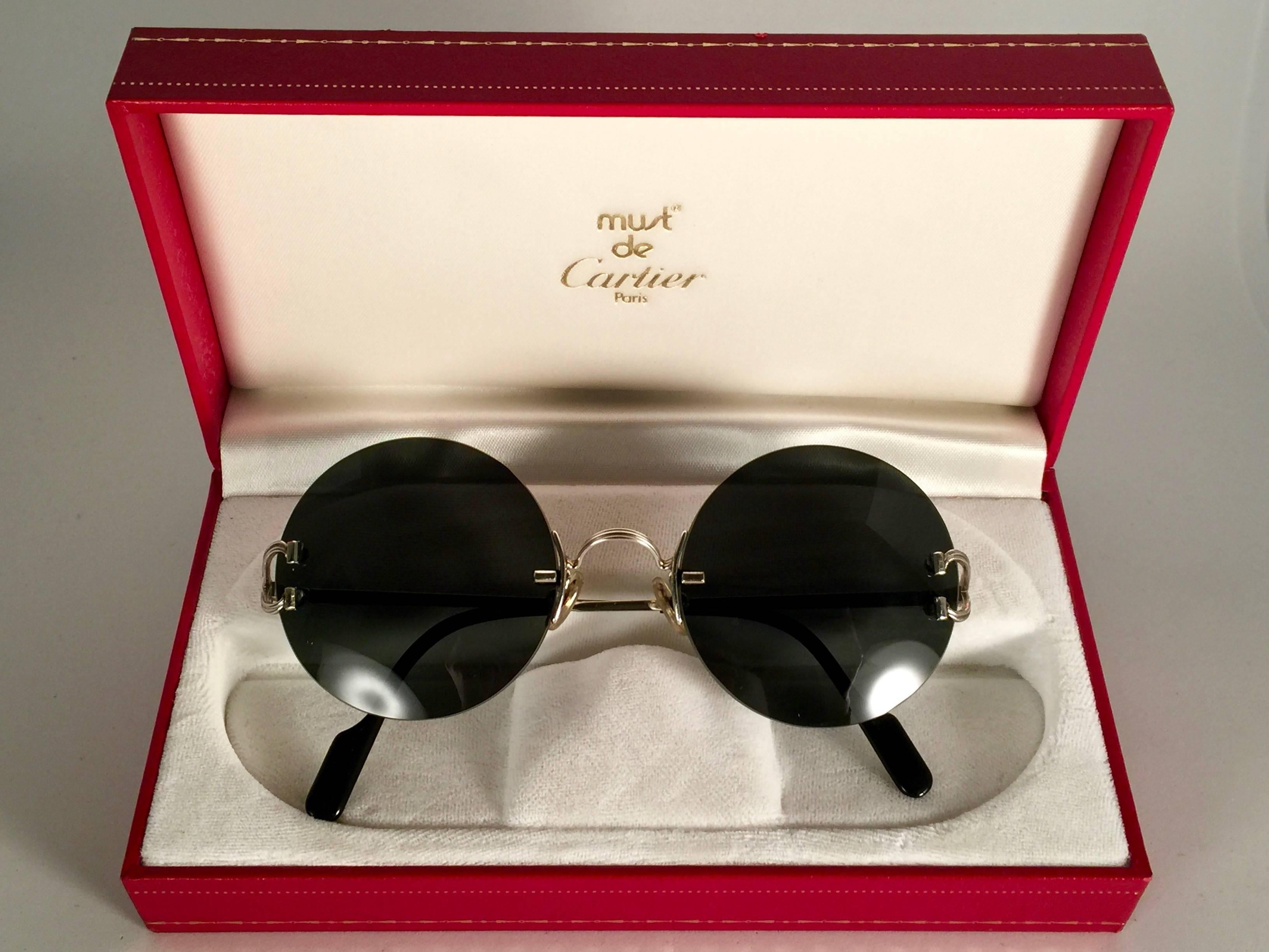 Neu 1990 Cartier Madison einzigartige Sonderausgabe randlose Sonnenbrille mit grauen (uv-Schutz) Gläsern. 
Rahmen mit Front und Seiten aus Platine. 
Cartier Platine-Zeichen auf den schwarzen Onyx-Ohrpassstücken. 
Sie sind wie ein Paar Juwelen auf