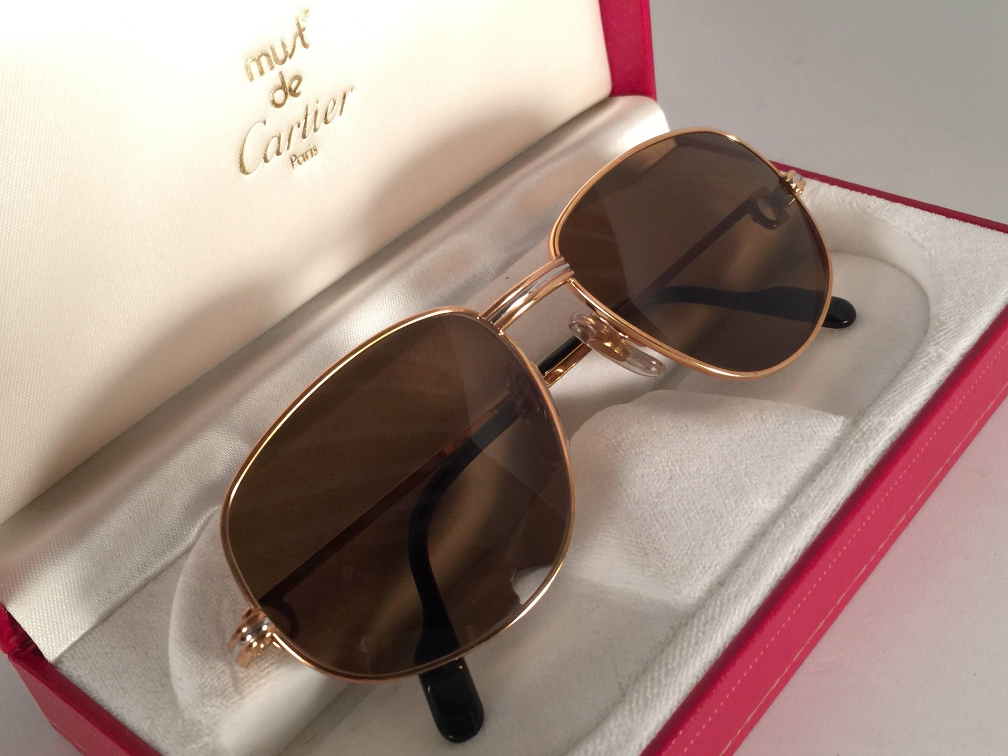 Rare rose gold Cartier Romance Santos sunglasses with brown (uv protection)lenses.  
Frame is with the front and sides in rose and white gold.  All hallmarks. 
Red enamel with Cartier gold signs on the ear paddles. 
Both arms sport the C from