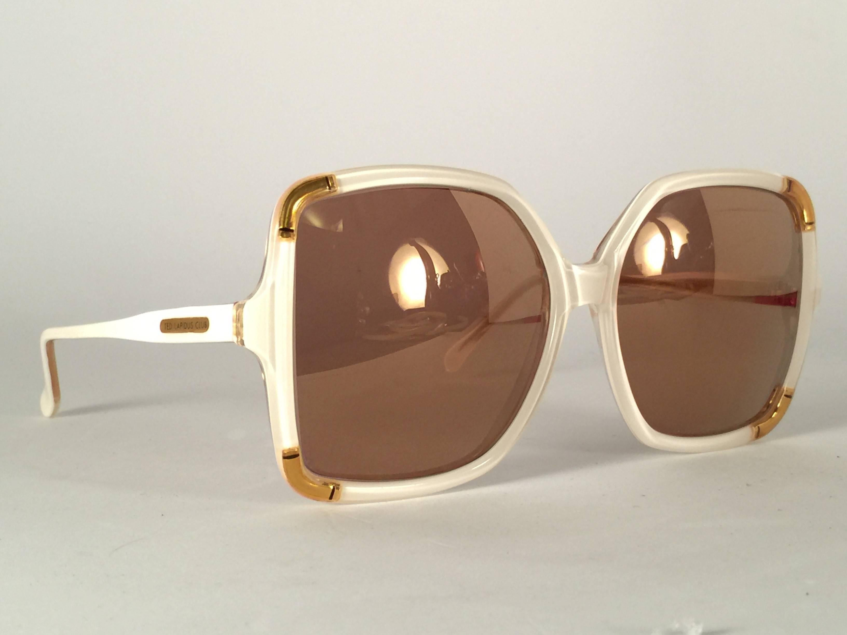 New Vintage Ted Lapidus Black & gold frame with spotless gold mirror lenses. Please consider that this item its nearly 50 years old and could show minor sign of wear or discolouration due to storage. 

Made in Paris. Produced and design in 1970's.