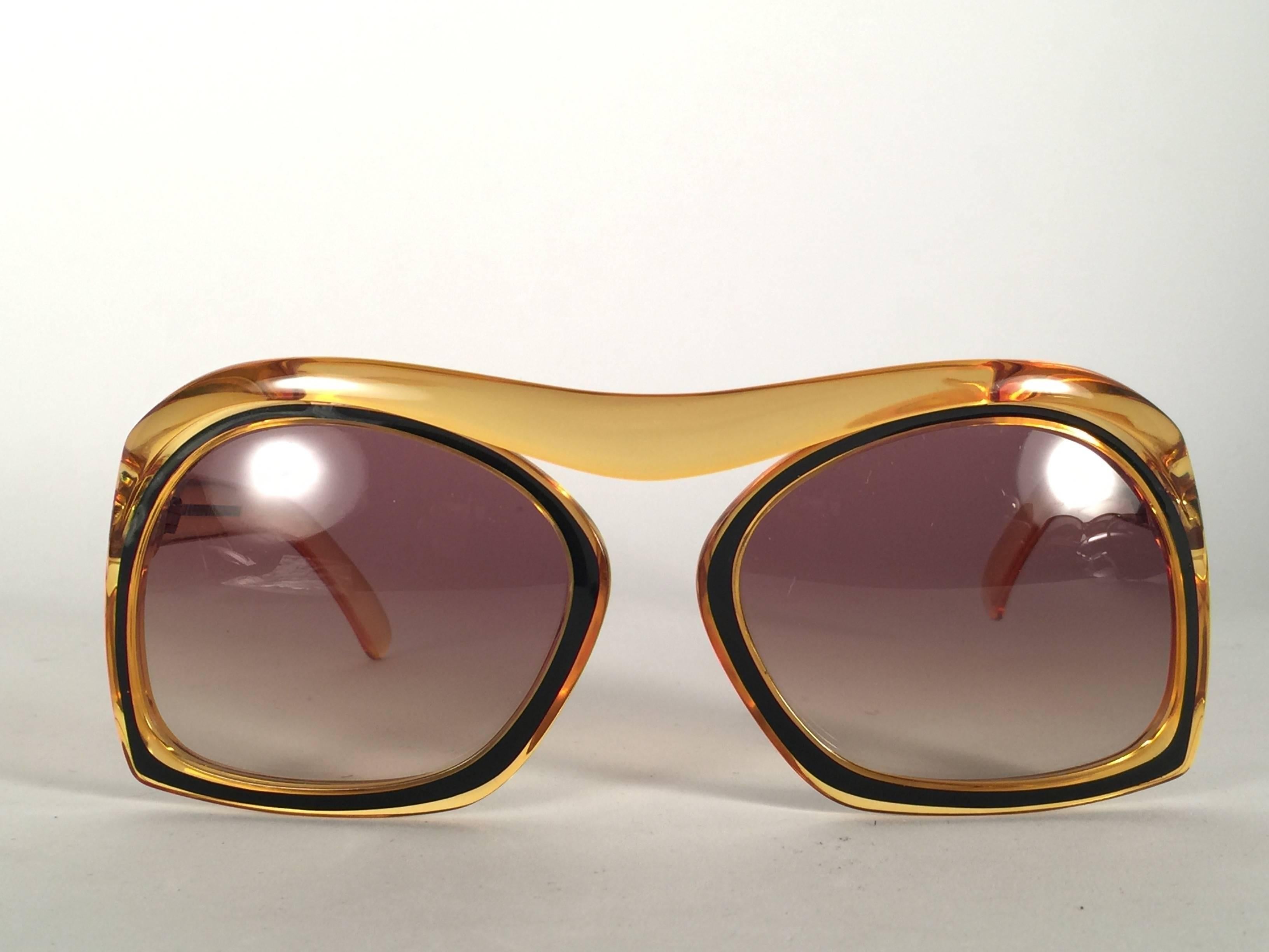 New Collectors Item. 

New Vintage Christian Dior 2043 10 Oversized amber with black accents frame sporting a pair of flawless gradient lenses.

Made in Austria.
 
Produced and design in 1970's.

New, never worn or displayed.



