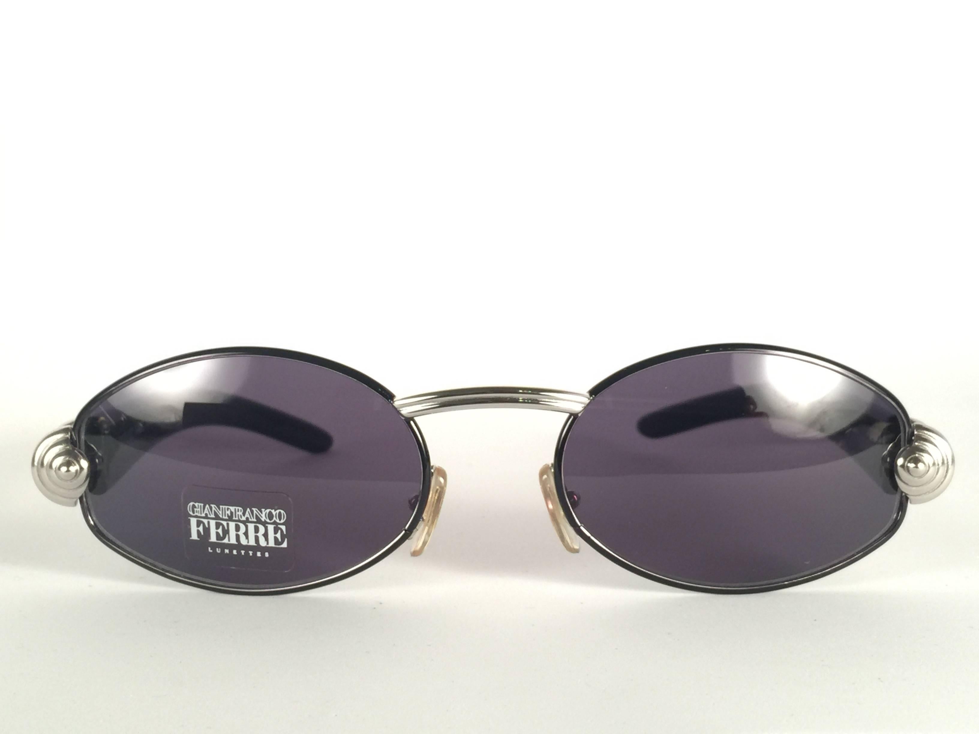 New vintage Gianfranco Ferre sunglasses.    

Oval silver accents frame holding a pair of grey  lenses.   

New, never worn or displayed. 

 Made in Italy.
