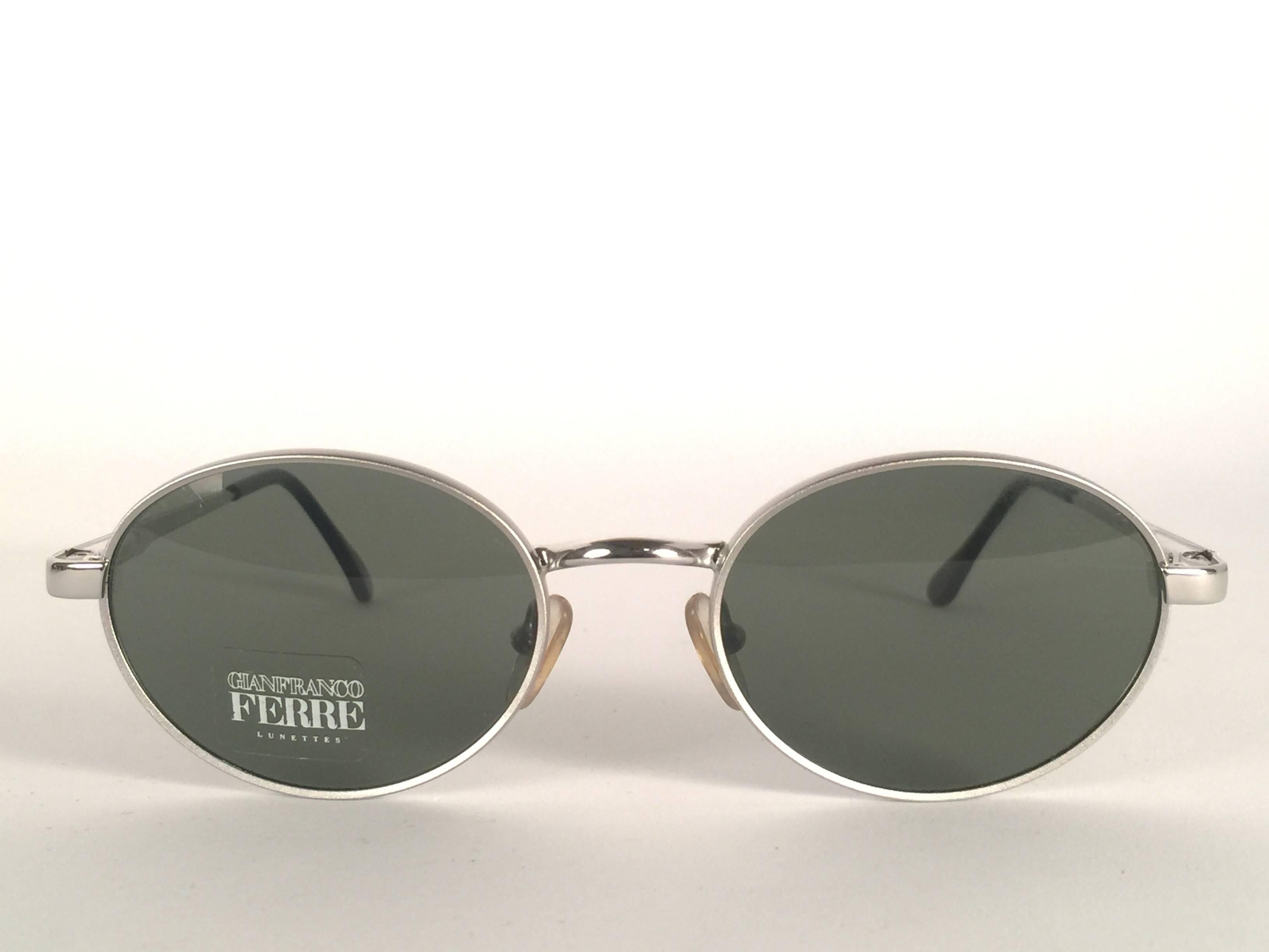 New vintage Gianfranco Ferre sunglasses.    

Oval silver frame holding a pair of spotless grey lenses.   

New, never worn or displayed. 

 Made in Italy.