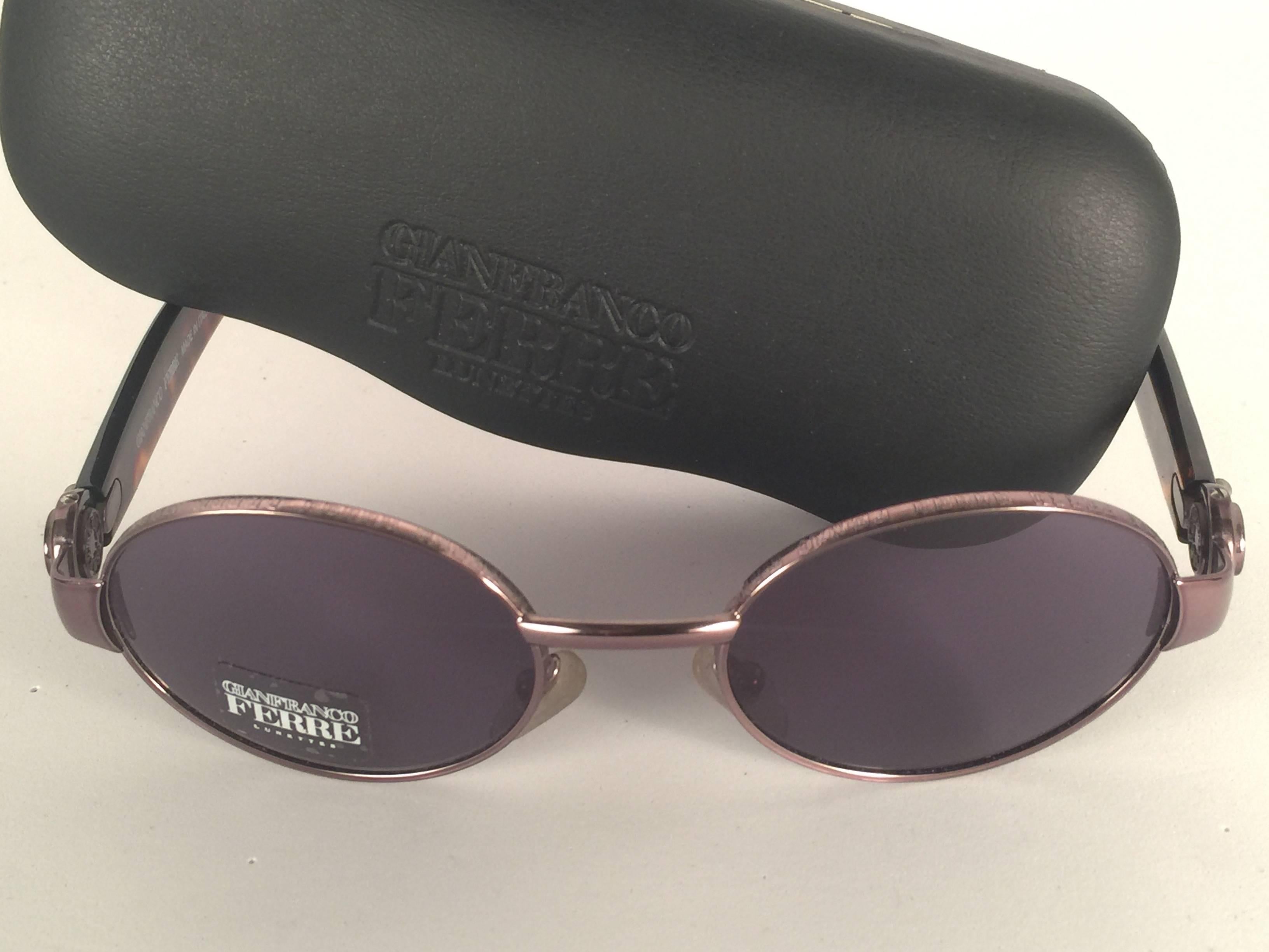 New vintage Gianfranco Ferre sunglasses.    

Oval copper and tortoise frame holding a pair of spotless grey lenses.   

New, never worn or displayed. 

 Made in Italy.