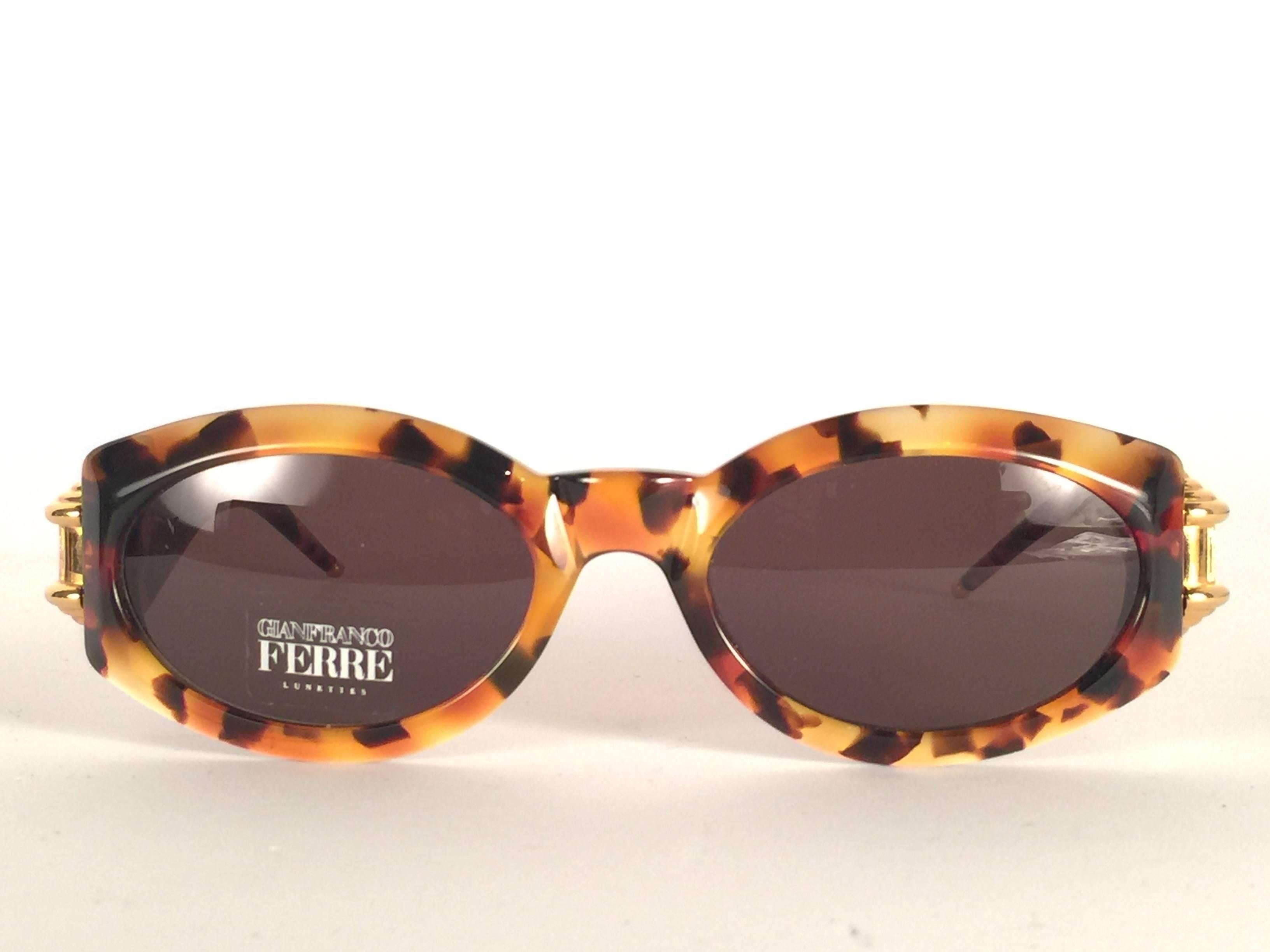 New vintage Gianfranco Ferre sunglasses.    

Tortoise with gold details frame holding a pair of spotless grey lenses.   

New, never worn or displayed. 

 Made in Italy.