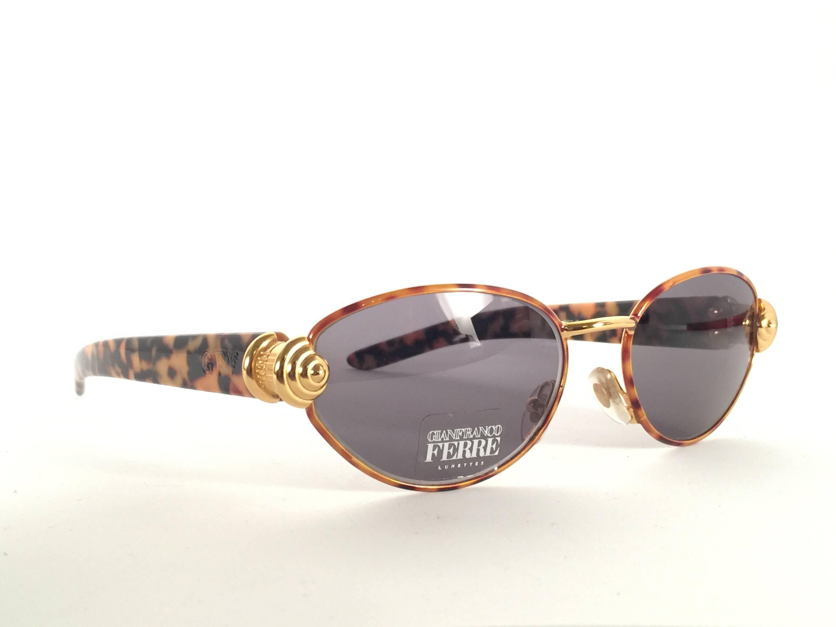 New vintage Gianfranco Ferre sunglasses.    

Tortoise and gold detailed frame holding a pair of spotless grey lenses.   

New, never worn or displayed. 

Comes with its original case.

 Made in Italy.