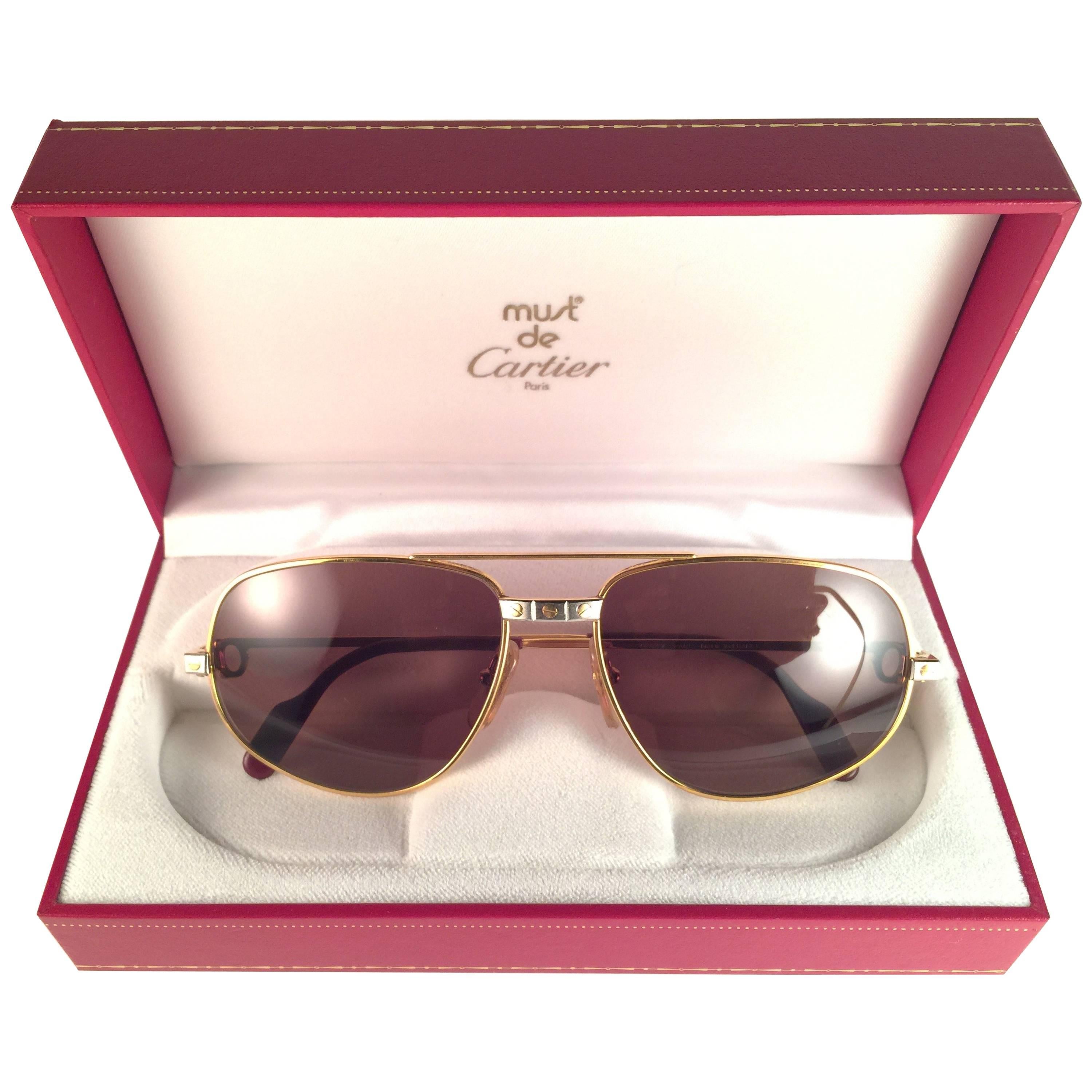 Vintage Cartier Romance Santos sunglasses with the honey brown (uv protection)lenses.  Frame is with the front and sides in yellow and white gold. All hallmarks. Red enamel with Cartier gold signs on the ear paddles. Both arms sport the C from