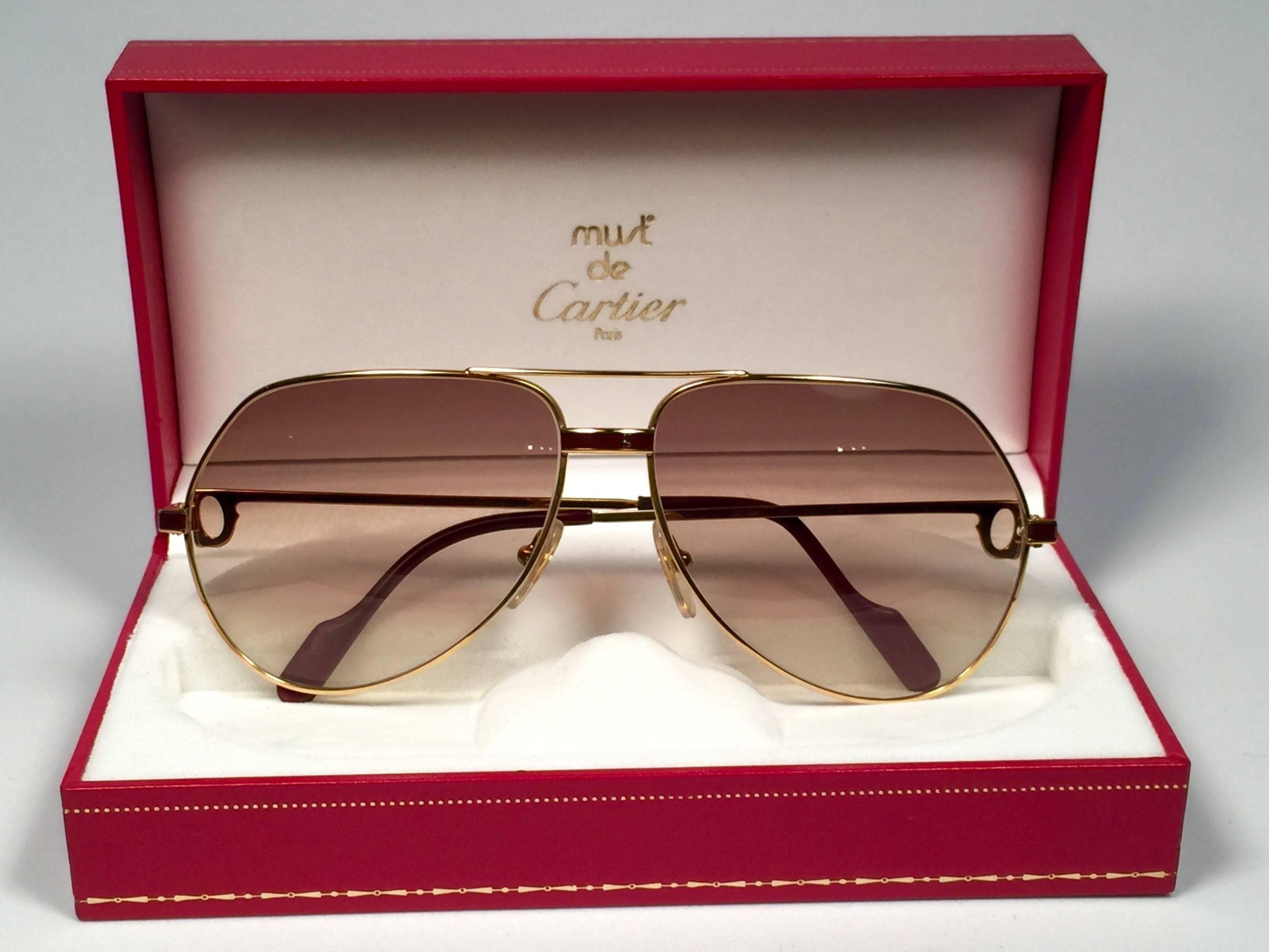 Von 1983!!! Cartier Aviator Laque de Chine Schwer vergoldete Sonnenbrille mit braunem Farbverlauf (UV-Schutz) Gläser.
Alle Markenzeichen. 
Rote Emaille mit goldenen Cartier-Zeichen auf den Ohrmuscheln. 
Beide Arme tragen das C von Cartier an den