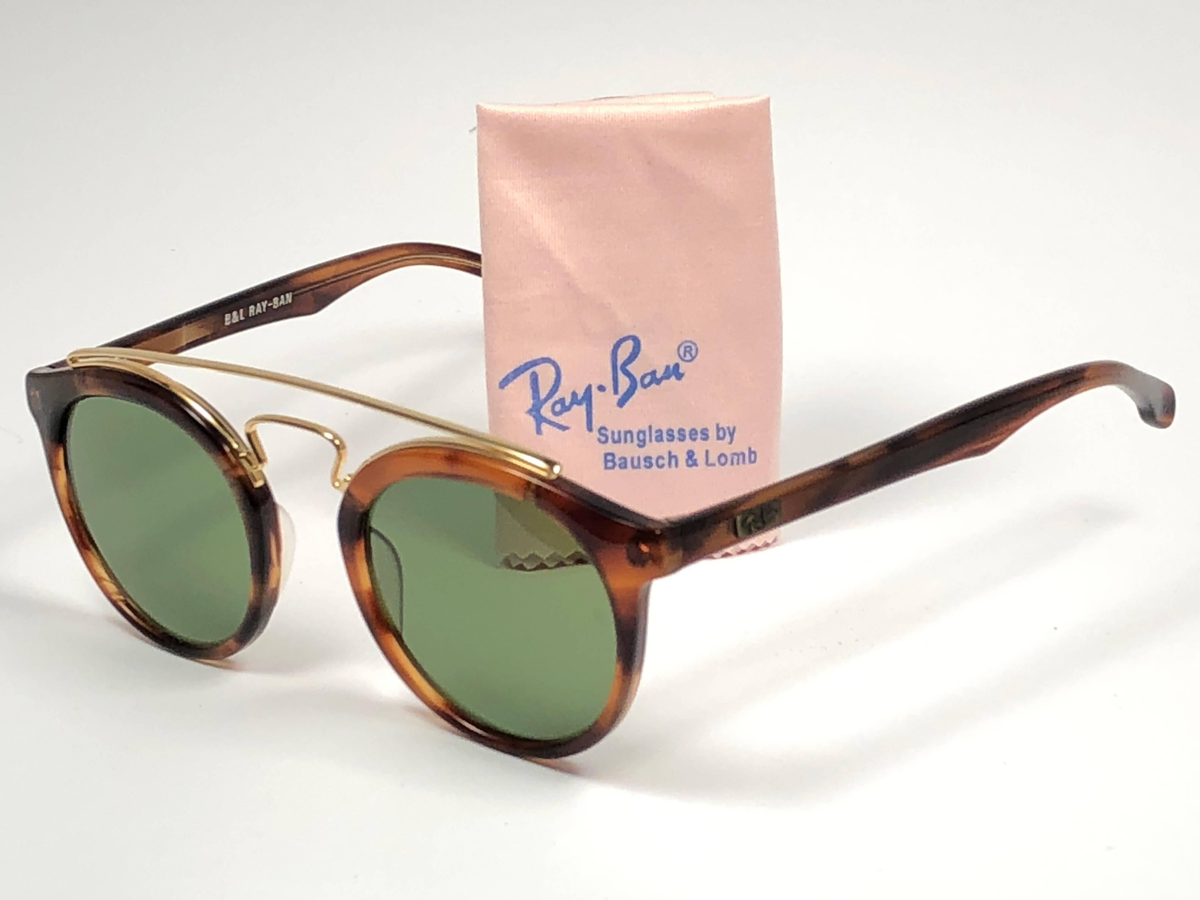 New Vintage Ray Ban Oval Gold Gatsby frame with RB3 Green Lenses without Ray Ban logo. Comes with its original Ray Ban B&L case.  
This piece may show minor sign of wear due to storage.  
A seldom piece in new, never worn or displayed condition.