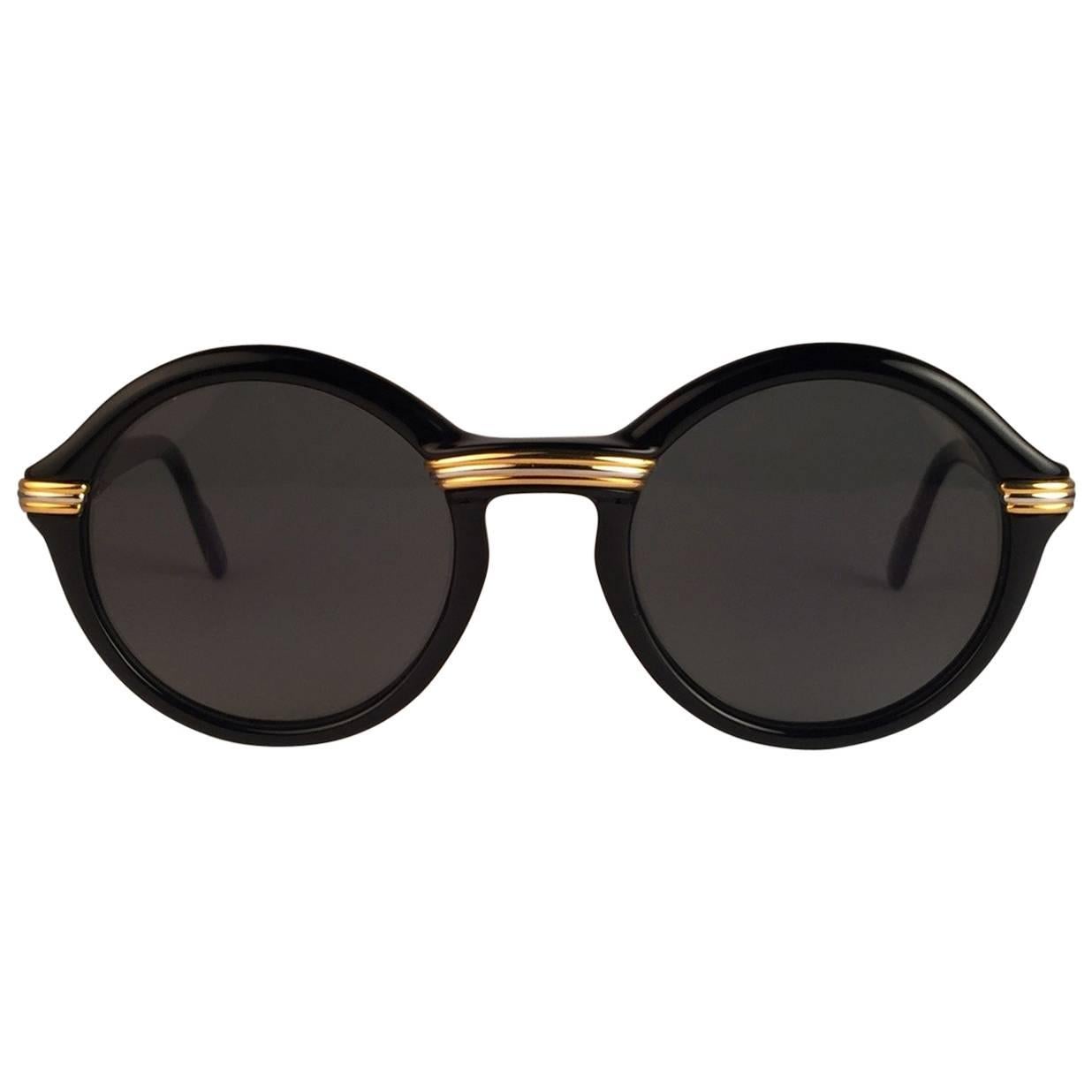 New 1991 Original Cartier Cabriolet Art Deco Black & Gold Sunglasses with gold ( uv protection ) lenses
Frame has the famous real gold and white gold accents in the middle and on the sides. 
All hallmarks. Cartier gold signs on the earpaddles. Both