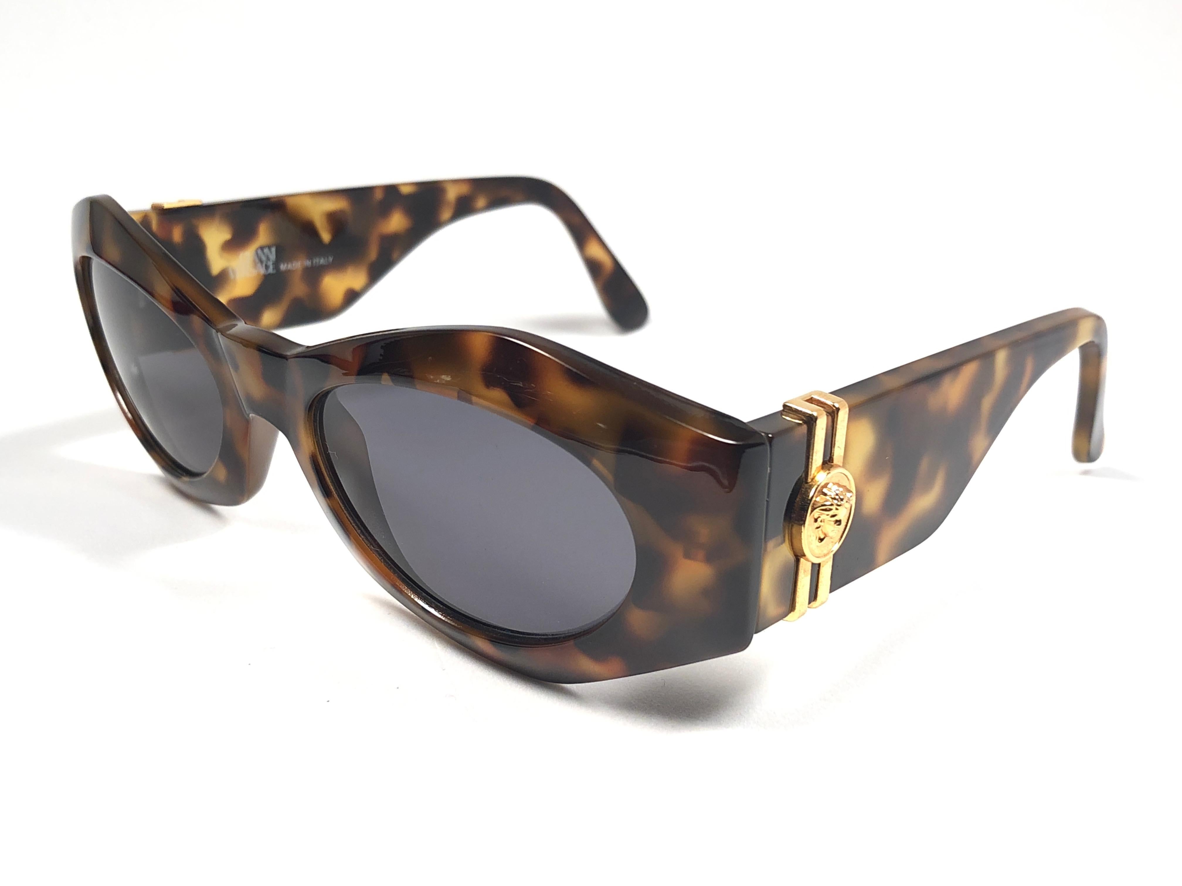 New Vintage Gianni Versace medium tortoise with gold accents frame with medium grey lenses.

New never worn or displayed. This pair could show minor sign of wear due to storage.

Made in italy.