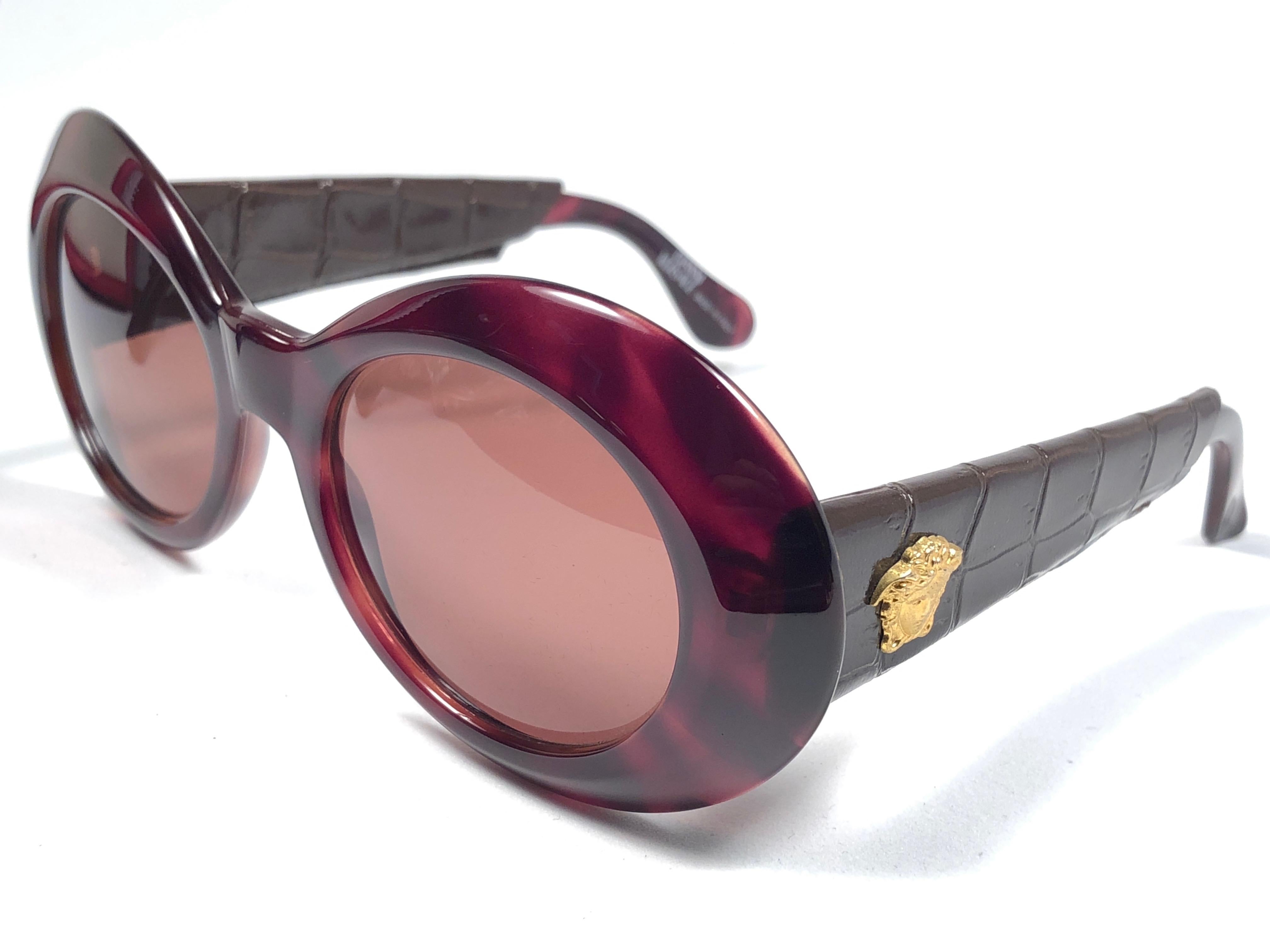 New Vintage Gianni Versace amber tortoise oval with gold accents, faux leather covered temples frame with medium brown lenses.

New never worn or displayed. Comes with its original Gianni Versace sleeve and cleaning cloth.
This pair could show minor