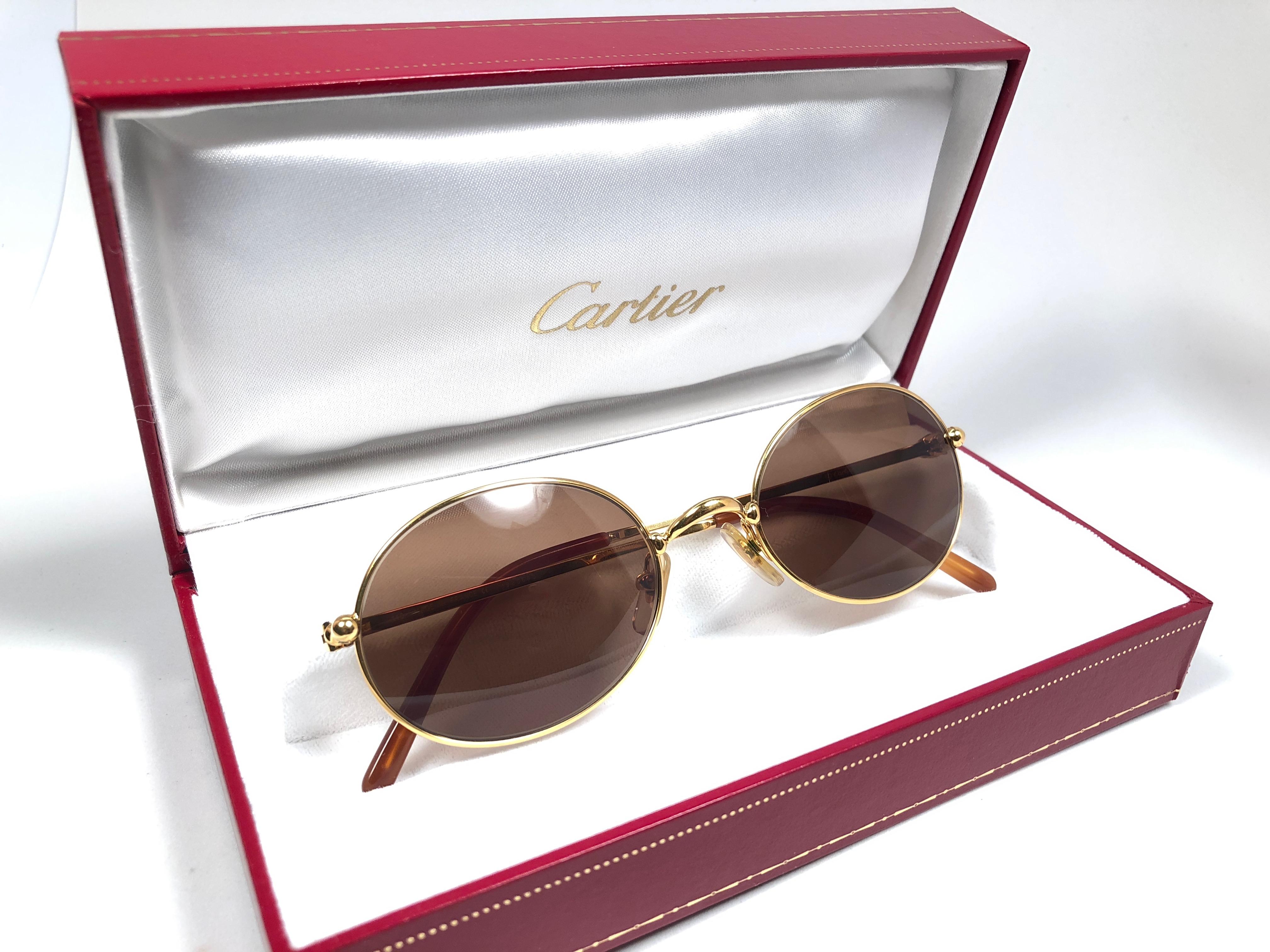 New 1990 Cartier Saturne Sunglasses with brown (uv protection) lenses.  All hallmarks.  Cartier gold signs on the ear paddles.  
These are like a pair of jewels on your nose. Please notice this pair is nearly 30 years old and may have minor sign of