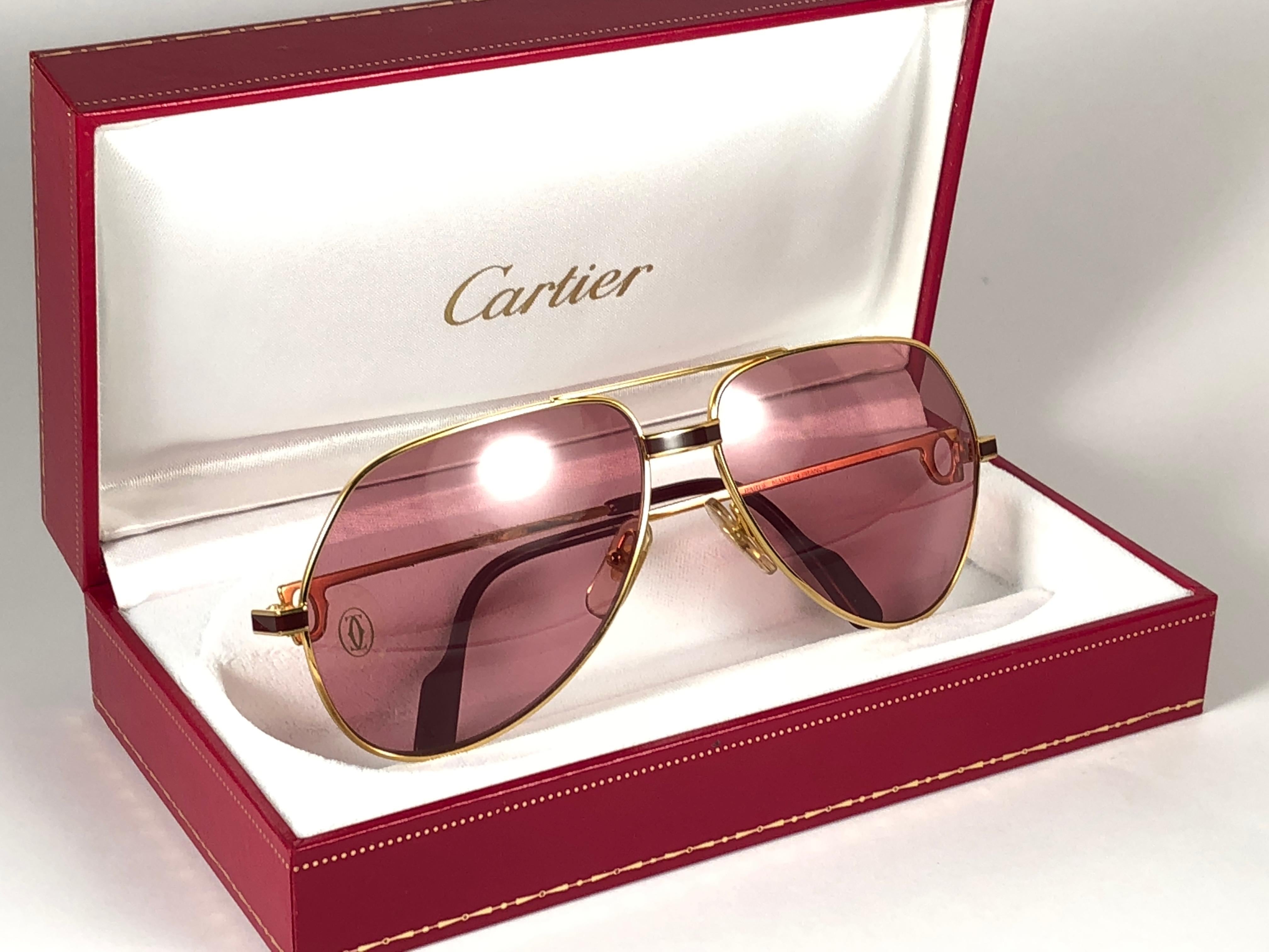 New from 1983!!! Cartier Aviator Laque de Chine Heavy plated gold sunglasses with original Cartier rose (uv protection) Lenses.
All hallmarks. 
Red enamel with Cartier gold signs on the ear paddles. 
Both arms sport the C from Cartier on the
