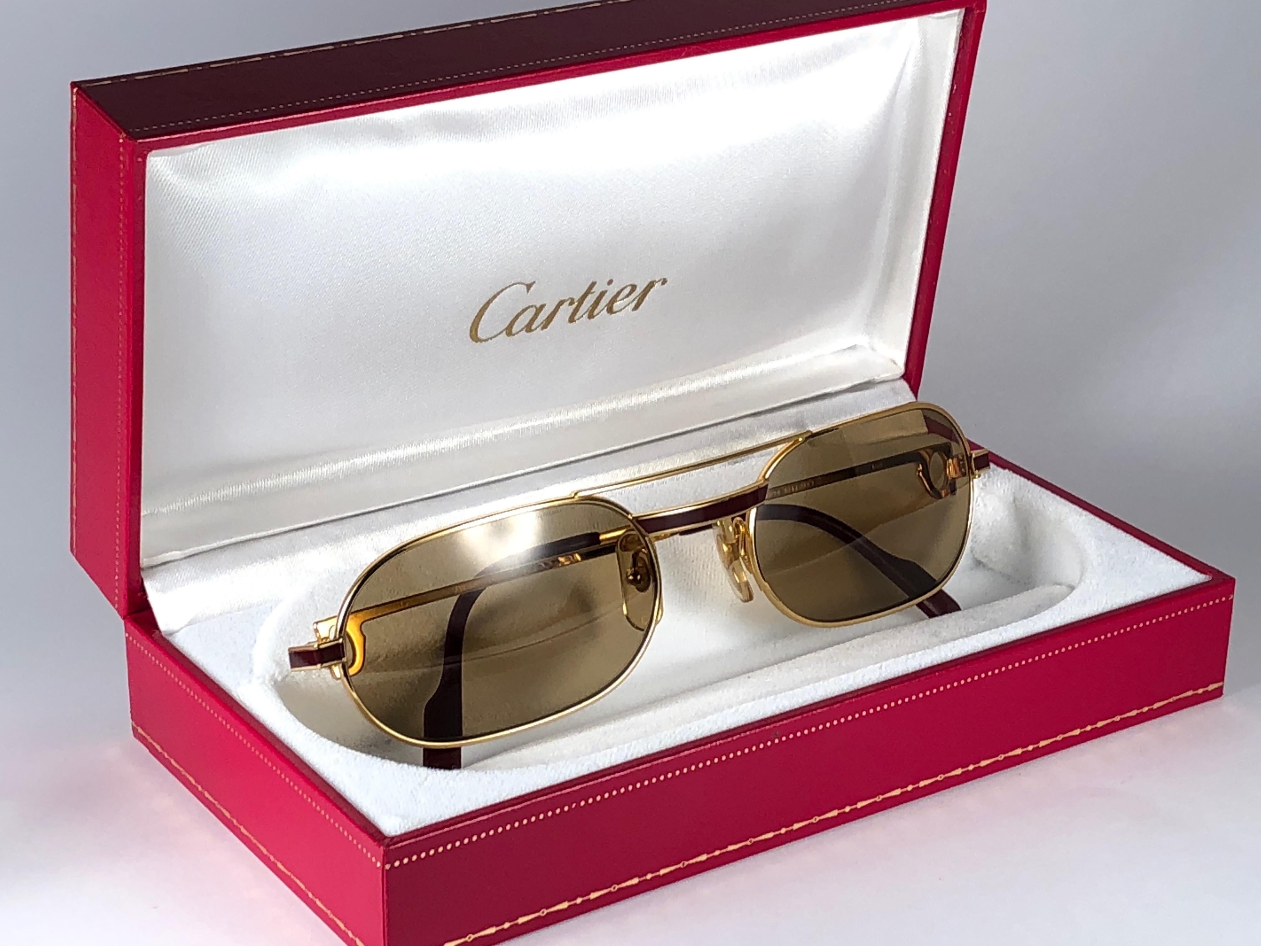 
Original 1983 Cartier Louis Cartier Laque De Chine sunglasses with original Cartier honey brown lenses.  All hallmarks. Red enamel with Cartier gold signs on the burgundy ear paddles. Both arms sport the C from Cartier on the temple. These are like