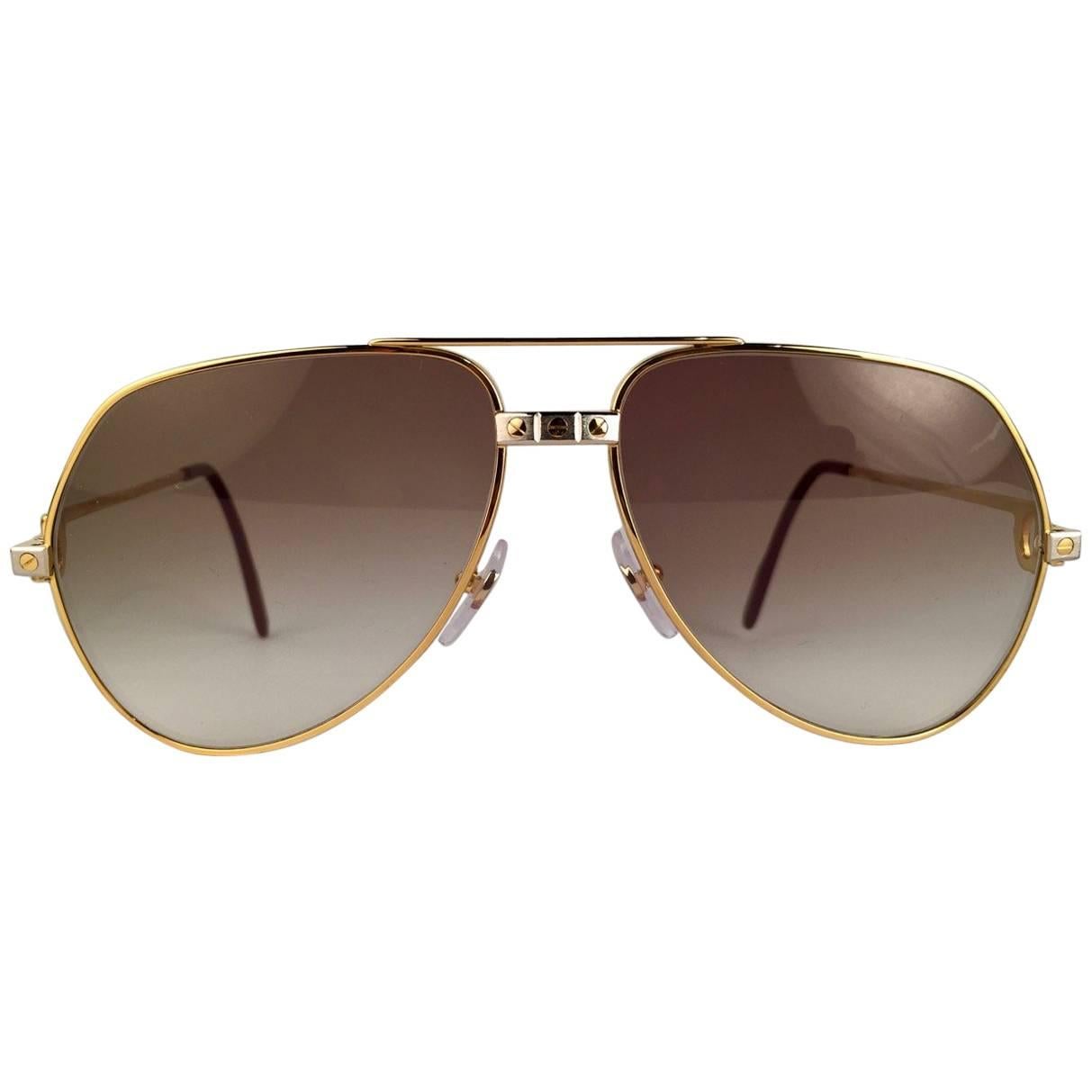Cartier Aviator Santos Sunglasses with Brown Gradient (uv protection) Lenses.  Frame is with the famous screws on the front and sides in yellow and white gold. All hallmarks. Red enamel with Cartier gold signs on the ear paddles.  Both arms sport