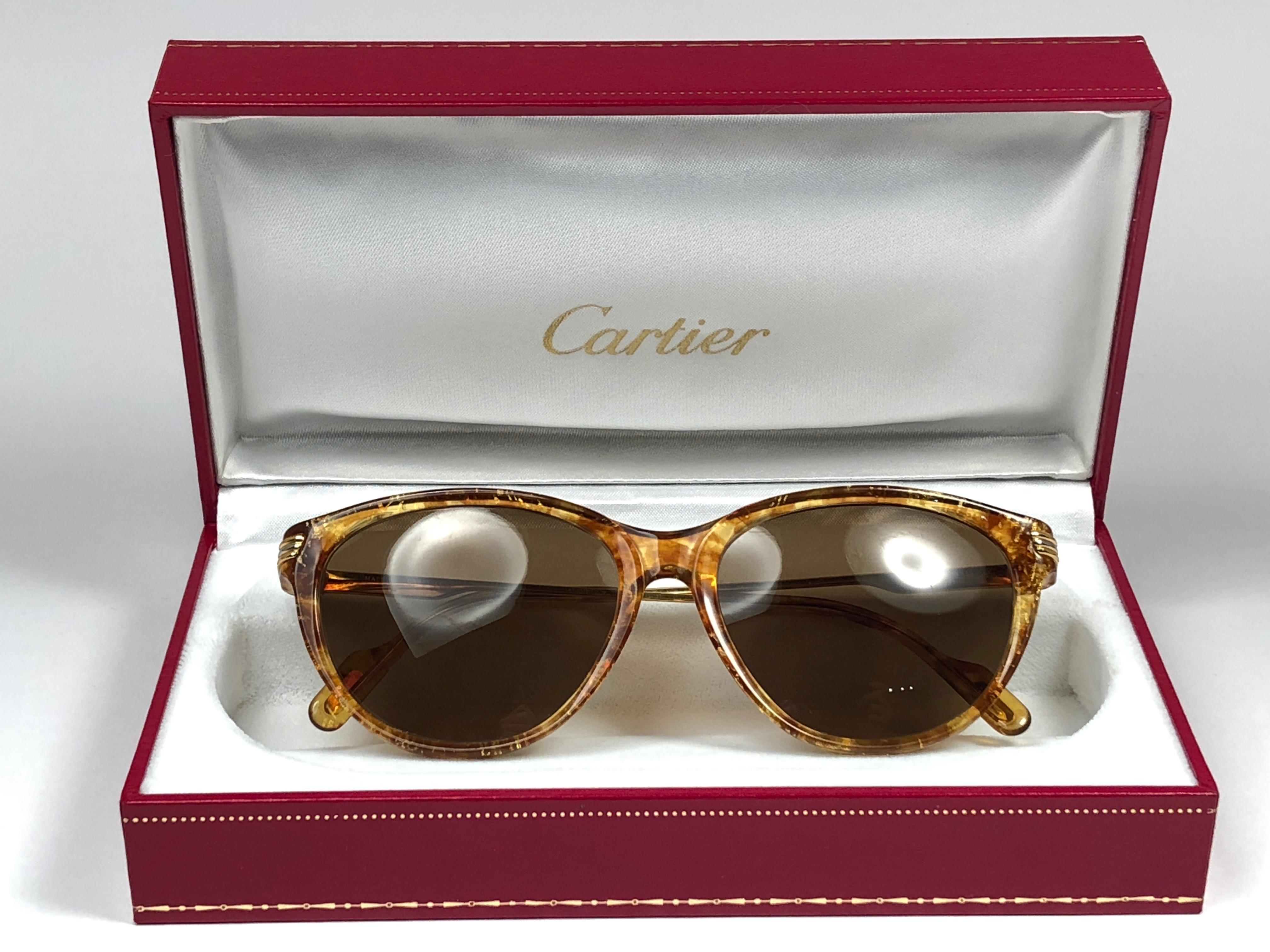 
New Cartier Eclat Classic sunglasses with brown (uv protection) lenses. Small size 53mm/15 frame has the famous real gold and white gold accents on the temples. 100% original. All hallmarks. Cartier gold signs on the earpaddles. These are like a