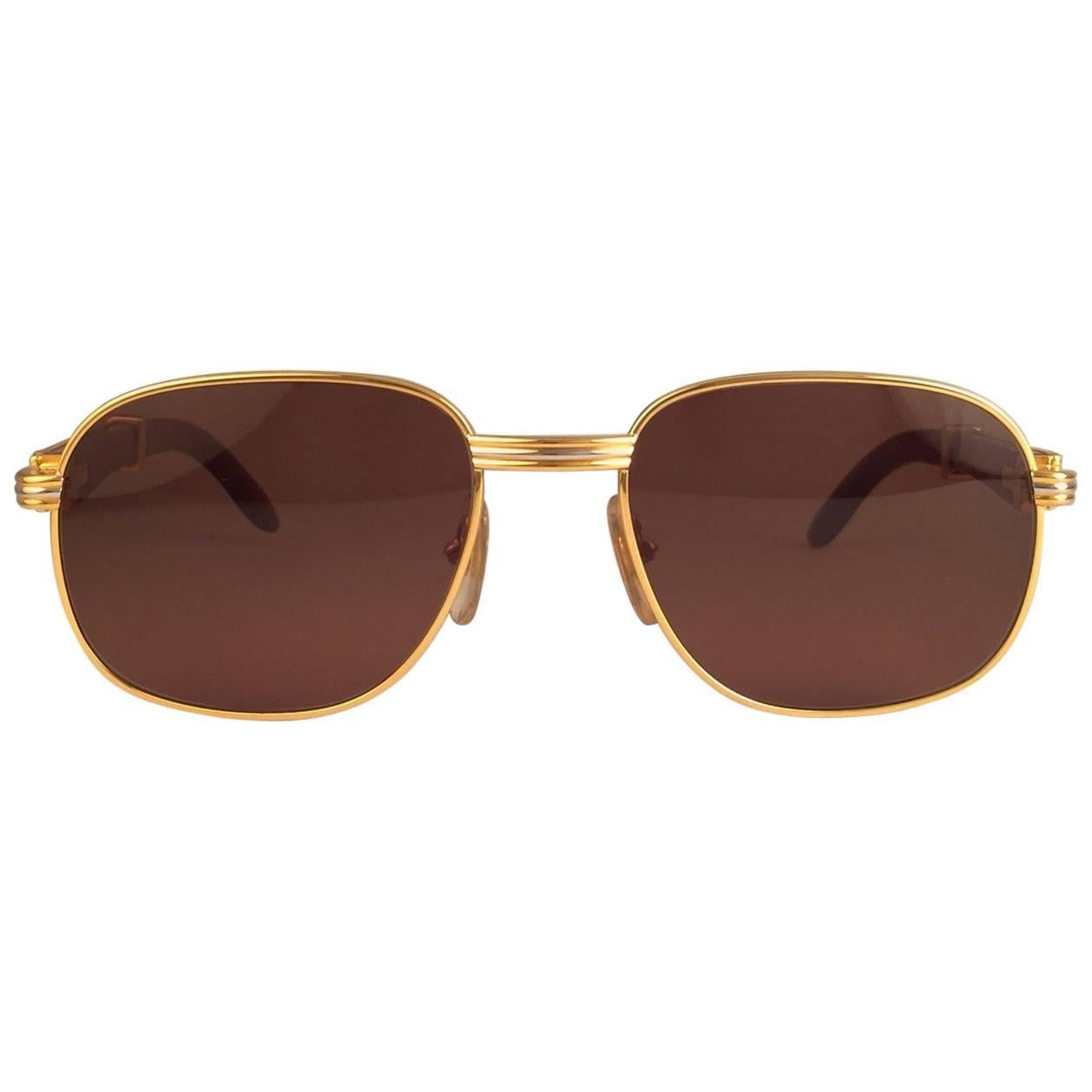 Nouvelles lunettes de soleil Cartier 1990 Full Set Monceau Palisander Hardwood avec de nouvelles lentilles solides brun miel (protection contre les UV). 
Cadre dont la face et les côtés sont en or jaune et blanc et qui présente les célèbres branches
