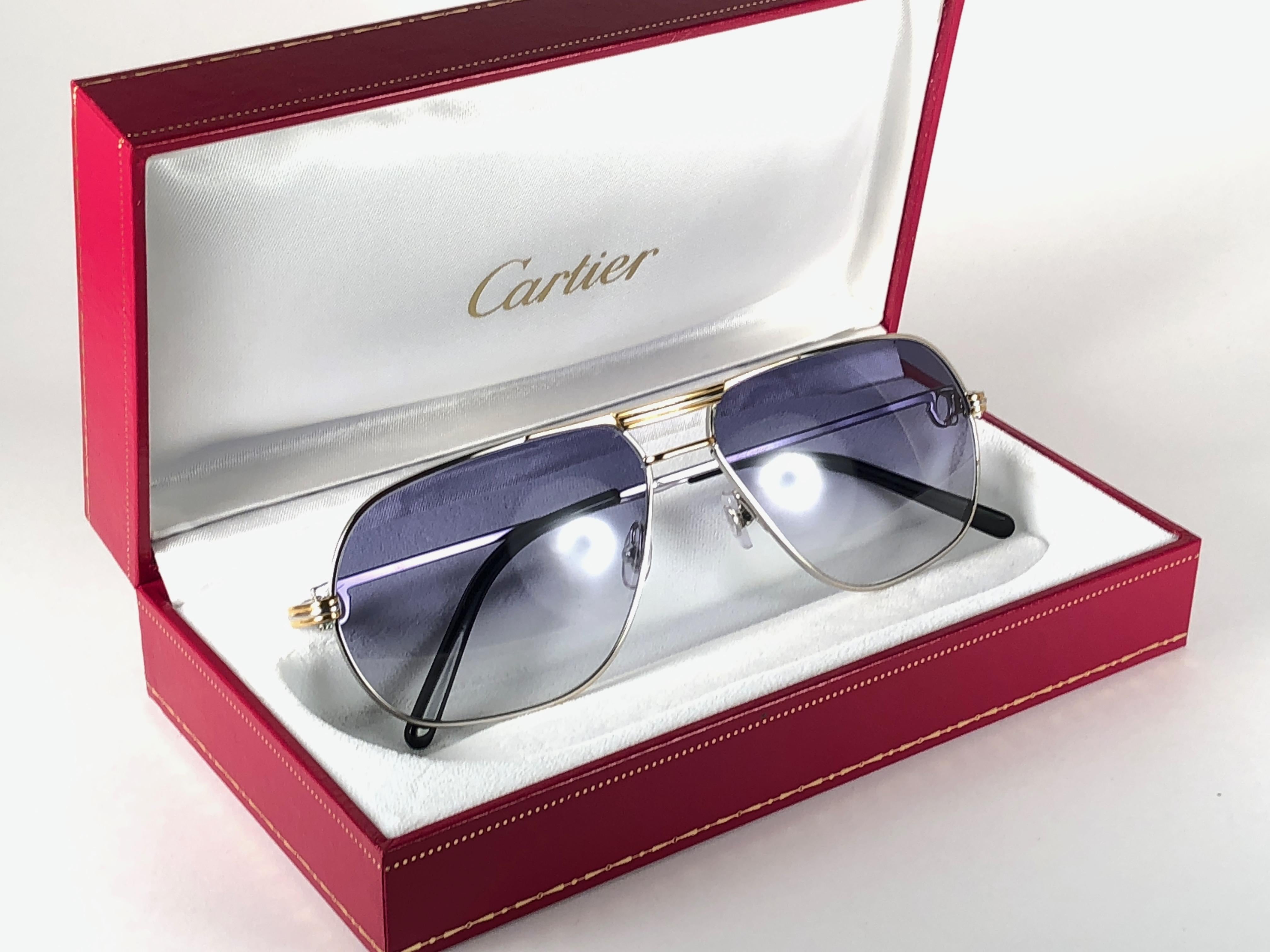 
New 1990 Cartier Tank platine Frame Sunglasses with blue gradient  (uv protection) lenses. 
Frame is with the front and sides in yellow and white gold. All hallmarks. Cartier signs on the ear paddles. These are like a pair of jewels on your