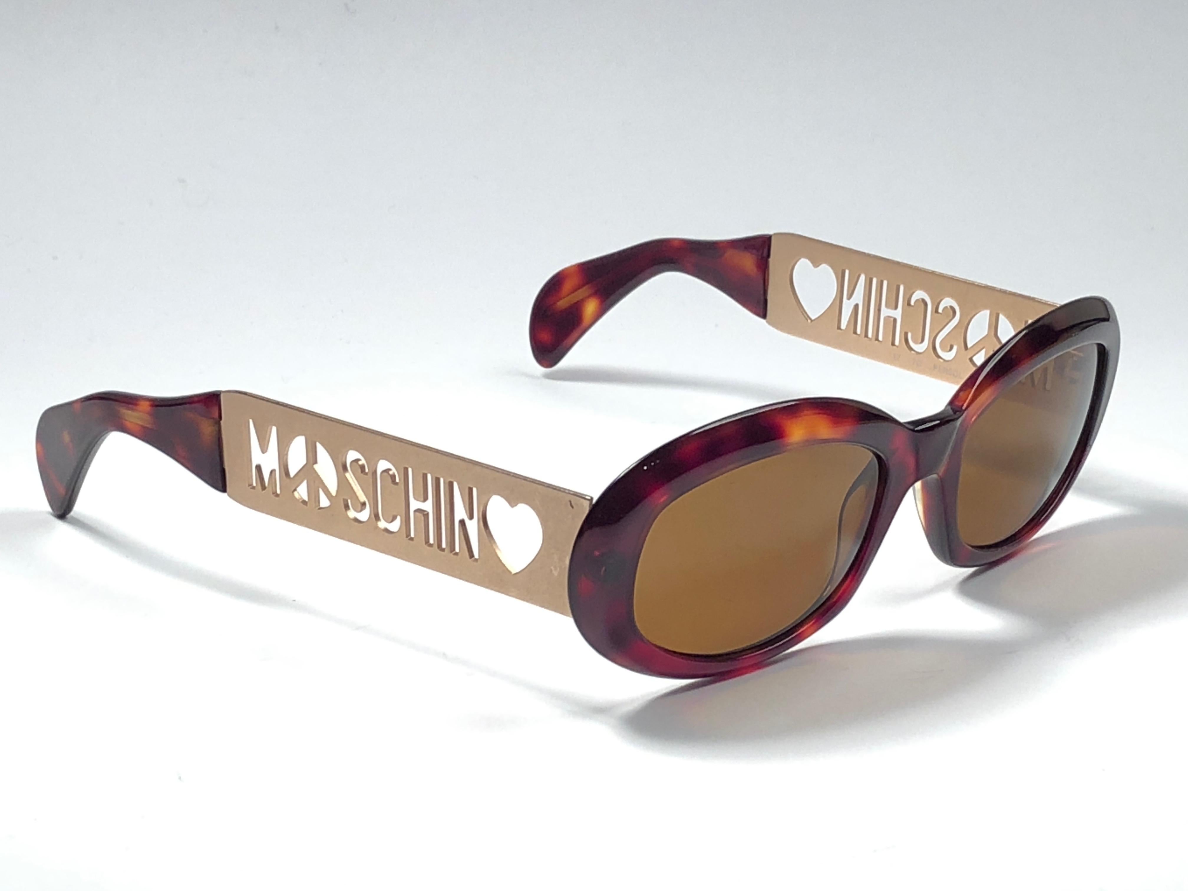 New Vintage Moschino small oval tortoise & gold frame with brown lenses.

Made in Italy.
 
Produced and design in 1990's.

New, never worn or displayed.
