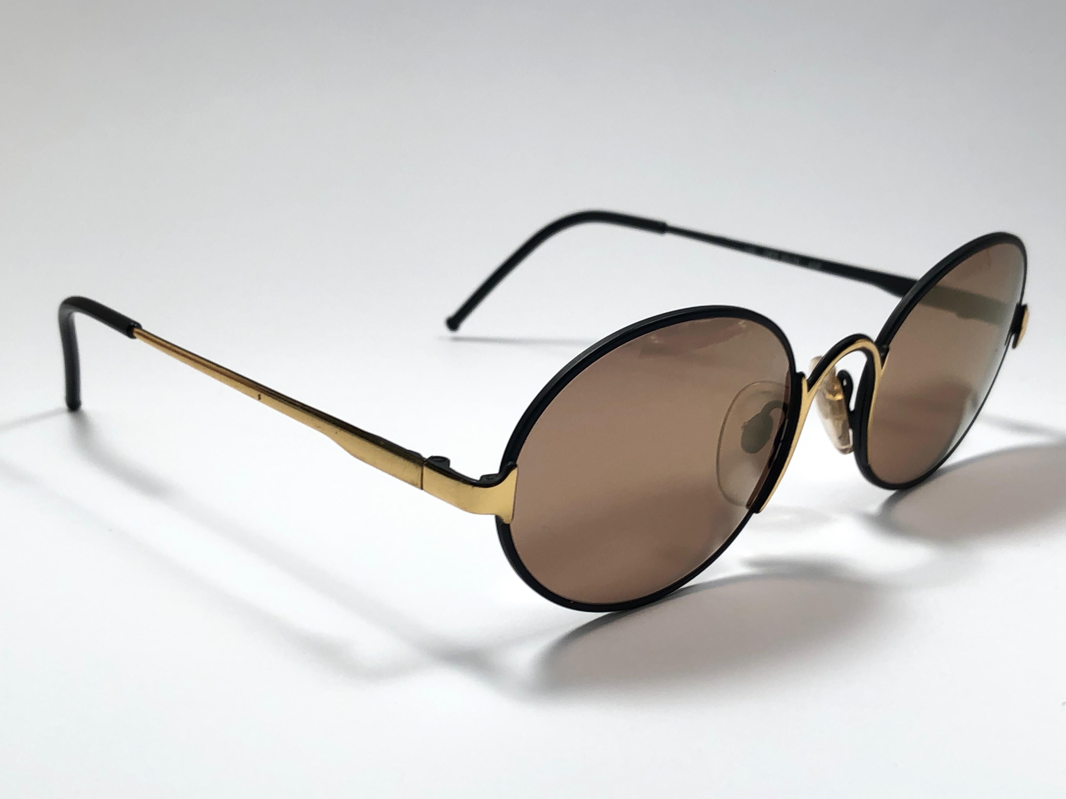 Nouvelles lunettes de soleil vintage Gianfranco Ferre.    

Monture noire avec des détails dorés contenant une paire de lentilles miroir dorées.   

Neuf, jamais porté ou exposé. 

 Fabriquées en Italie.