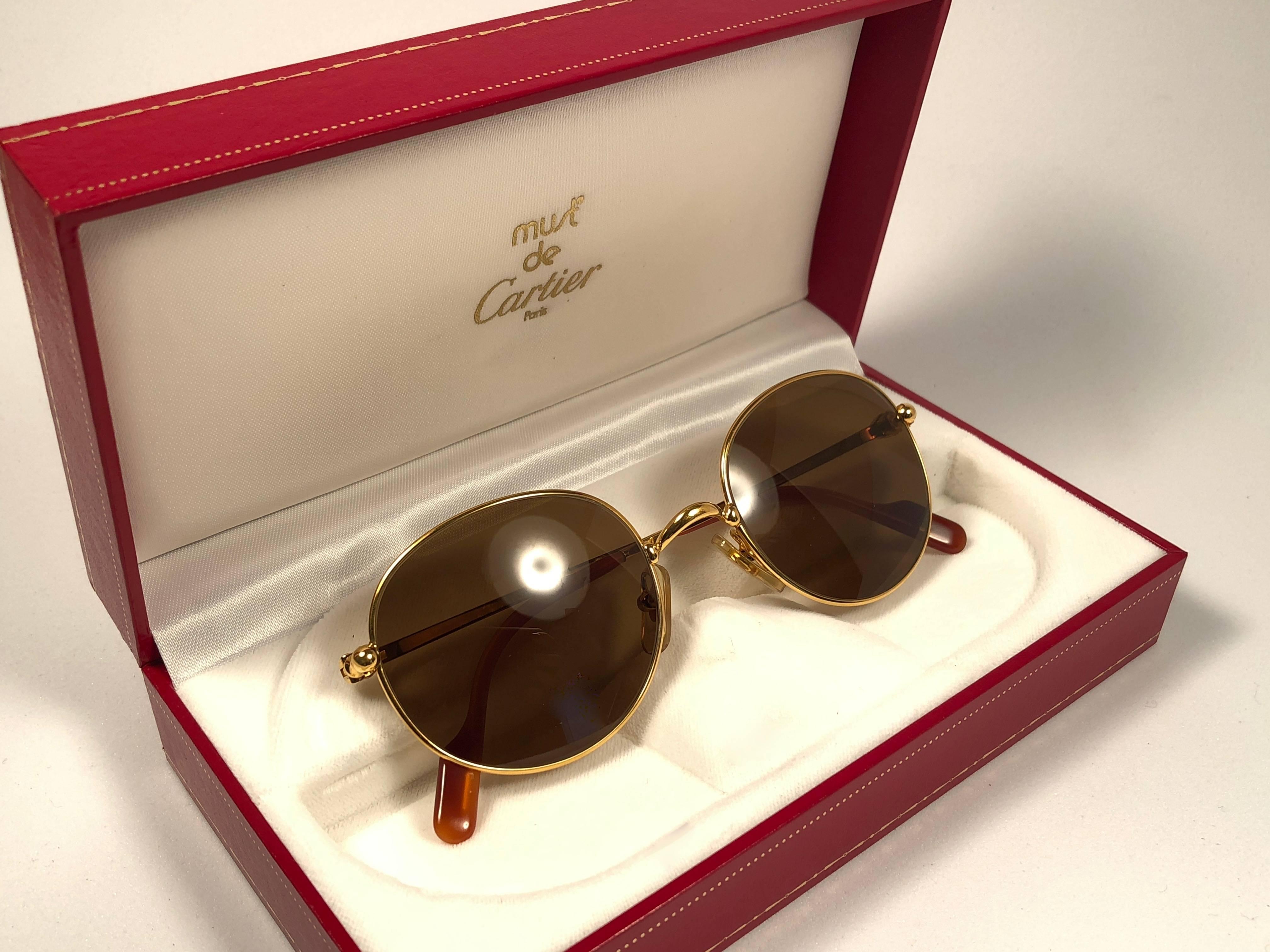 Mint Cartier oval Antares sunglasses with brown lenses(uv protection).  All hallmarks. Silver Cartier signs on the ear paddles. 
Both arms sport the knot from Cartier on the temple. These are like a pair of jewels on your nose. 

Please notice this