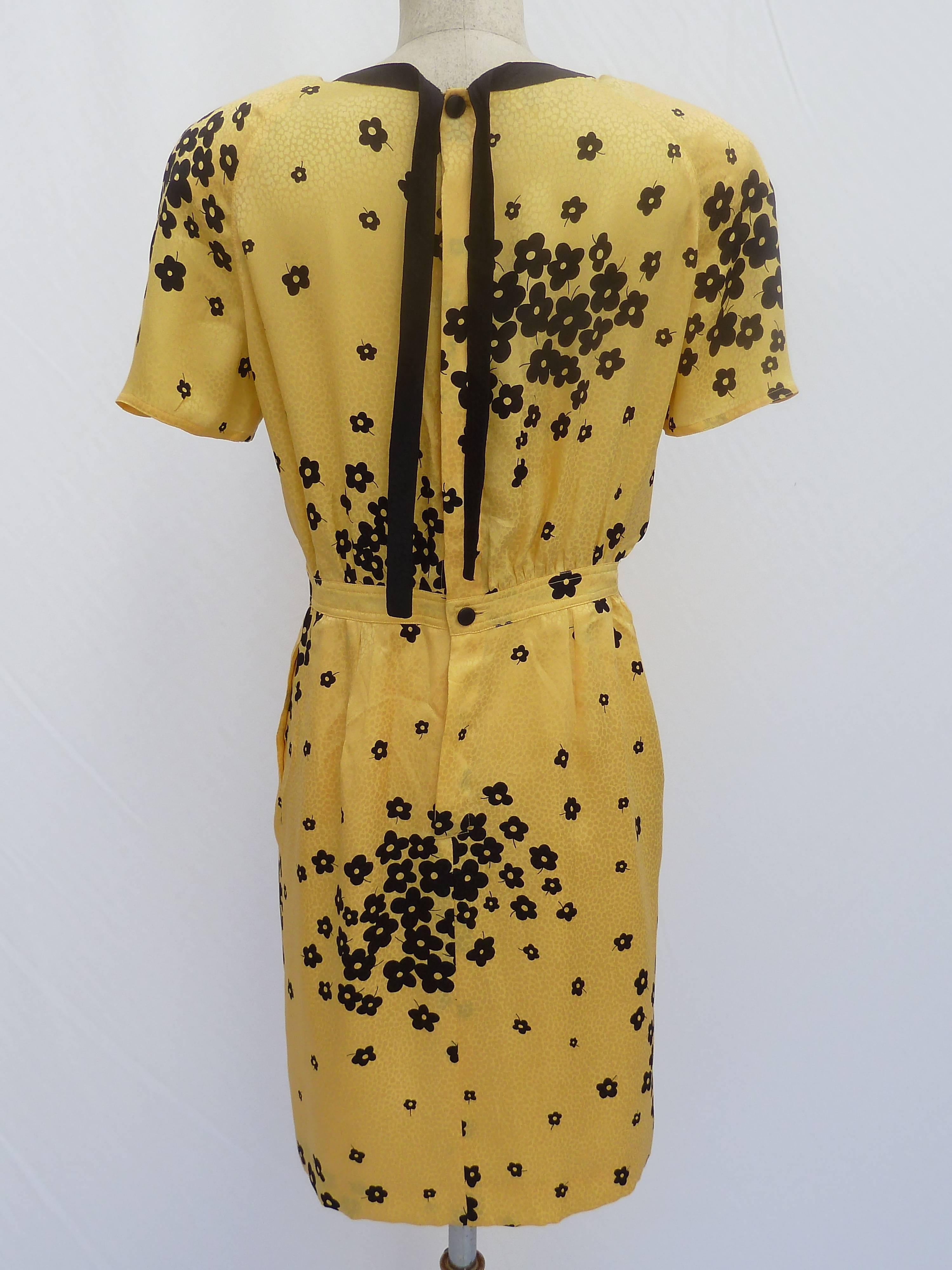 Valentino vintage dress 1990s. Yellow with floral patter. Strap on the back of the neck to tie a bow, button closure with internal strap, underskirt with anti-transparency lining. Vintage, excellent condition 

N.B. the label that proves the