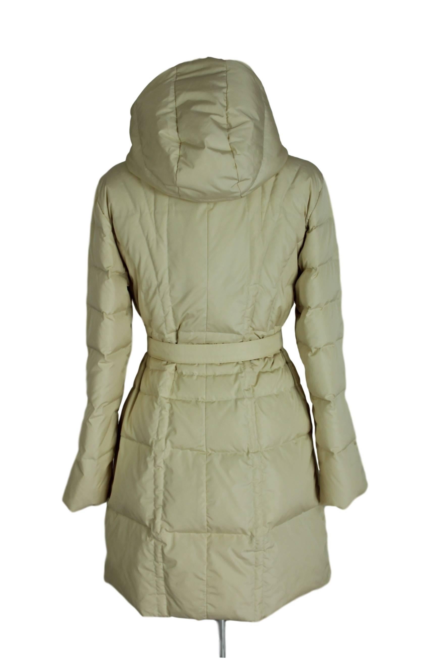 Moncler down jacket women white pearl with two hip pockets, closure with double slider zip and belted waist, removable hood.

Size: 1 
Measures:
Shoulders: 42 cm
Armpit to armpit: 46 cm
Total lenght: 96 cm 
Sleeves: 58 cm
Condition: excellent