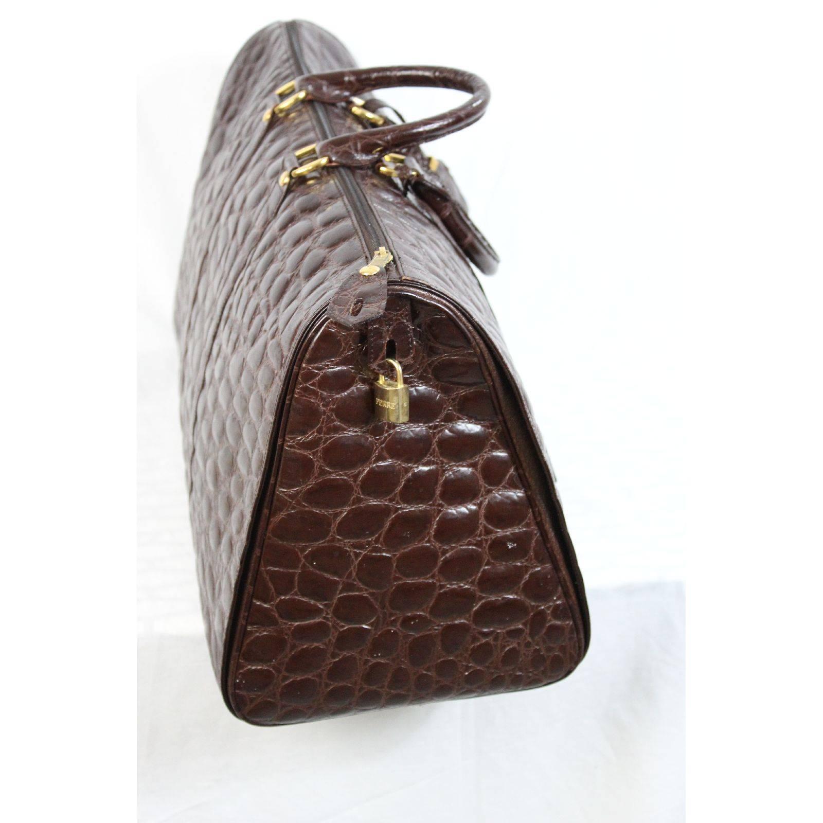 Gianfranco Ferre travel bag, brown in calfskin, embossed crocodile print. Strong handles, keys and golden padlock. Golden plate with serial number, inside canvas with logo pocket. Excellent vintage conditions. Shopping label.

Height: 34 cm
Width: