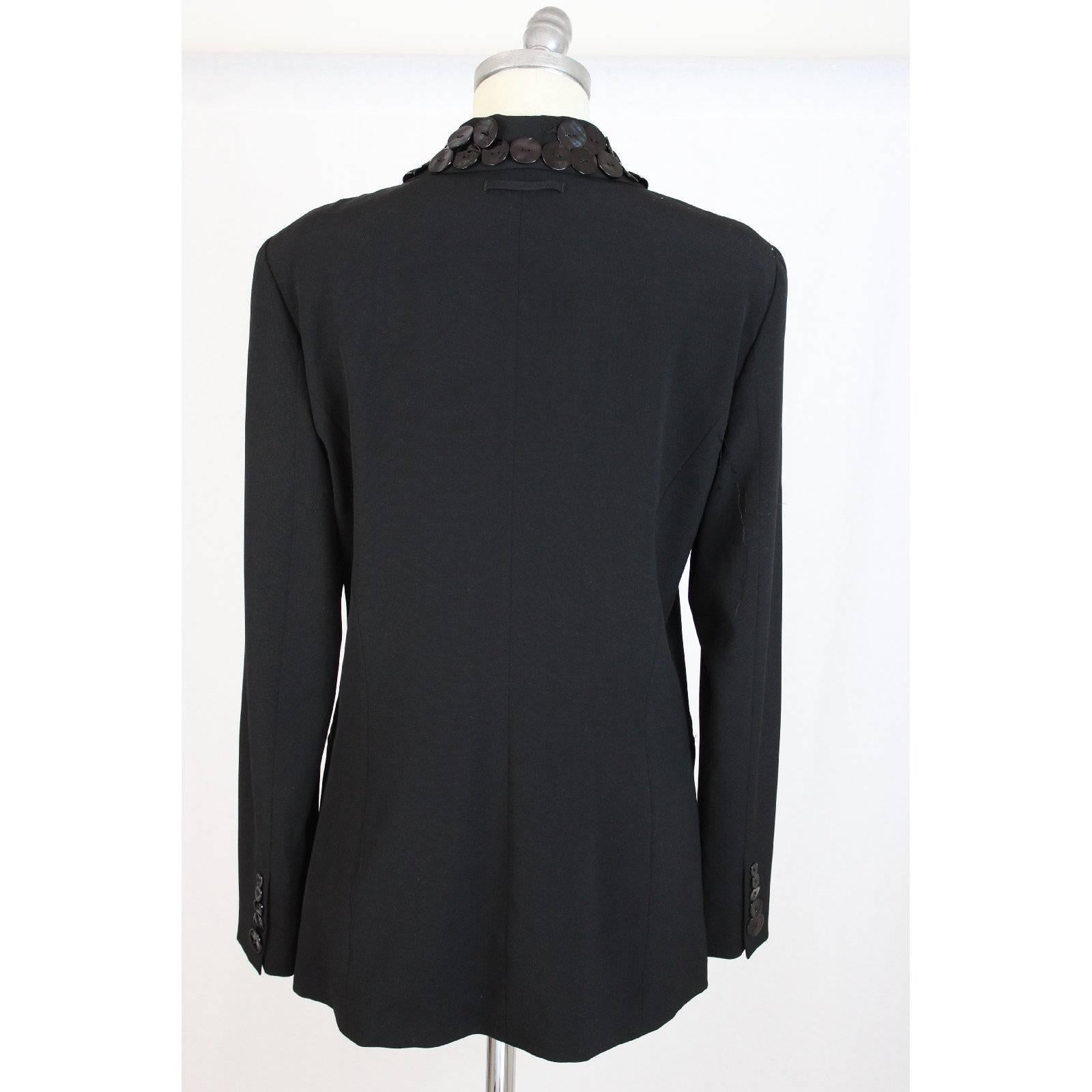 Jean Paul Gualtier vintage black wool jacket. The rever has applied buttons to mother pearl. This makes the jacket unique, a creation of rare high fashion. The size tag is not present. But we can confirm it’s a 12 Us. The jacket is 79 cm long, like