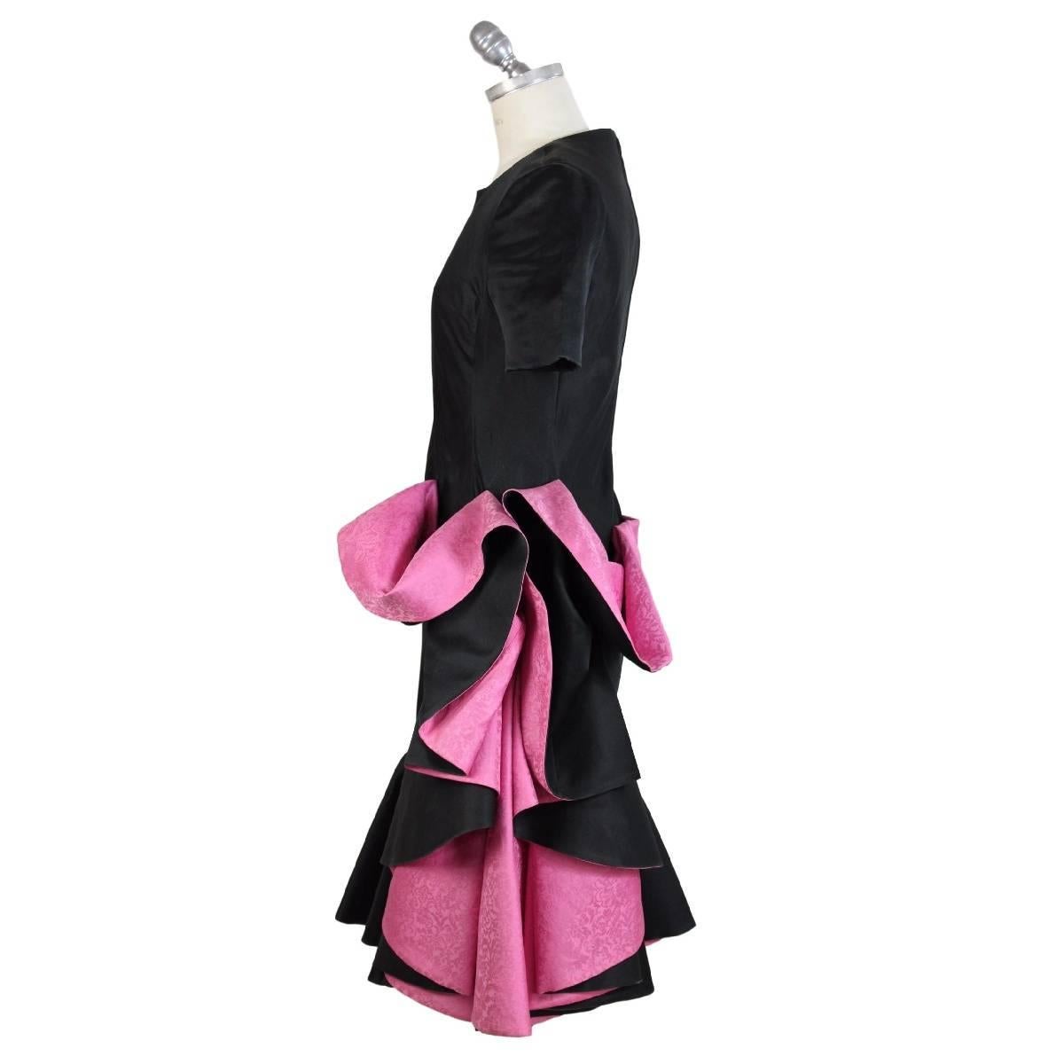 Roberto Capucci vintage silk black and fuchsia dress, cocktail dress length on the knee, short sleeve, crew neck, the skirt with fuchsia draping in silk shantung, zip closure on the back, size 42 it, made in italy, excellent condition.

Size 42