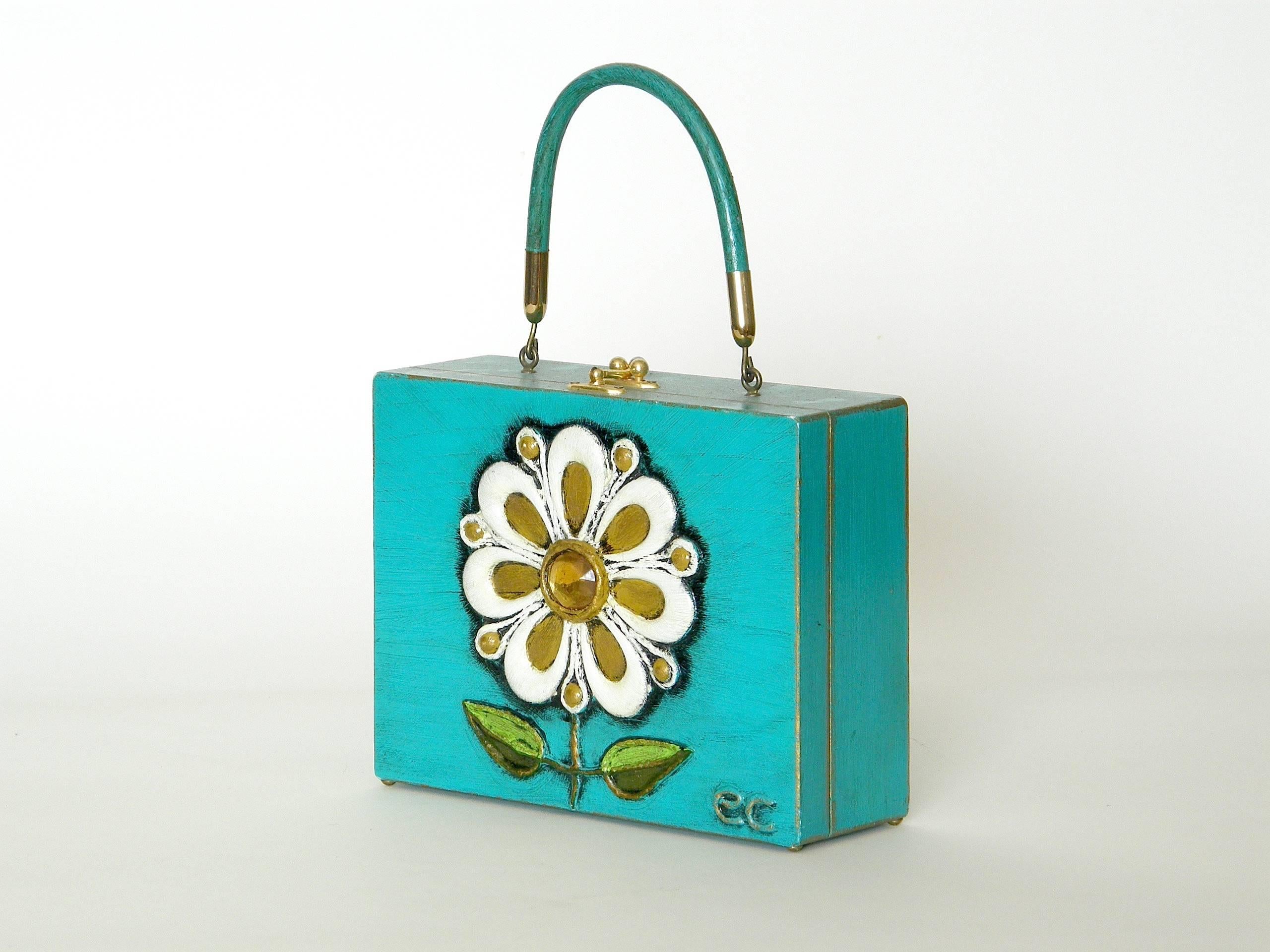 Cheerful, handmade papier mache box bag with jeweled flower by Enid Collins. It rests on little brass button feet.

The height given below is the overall height including the handle. The height of the box part only is 6.75
