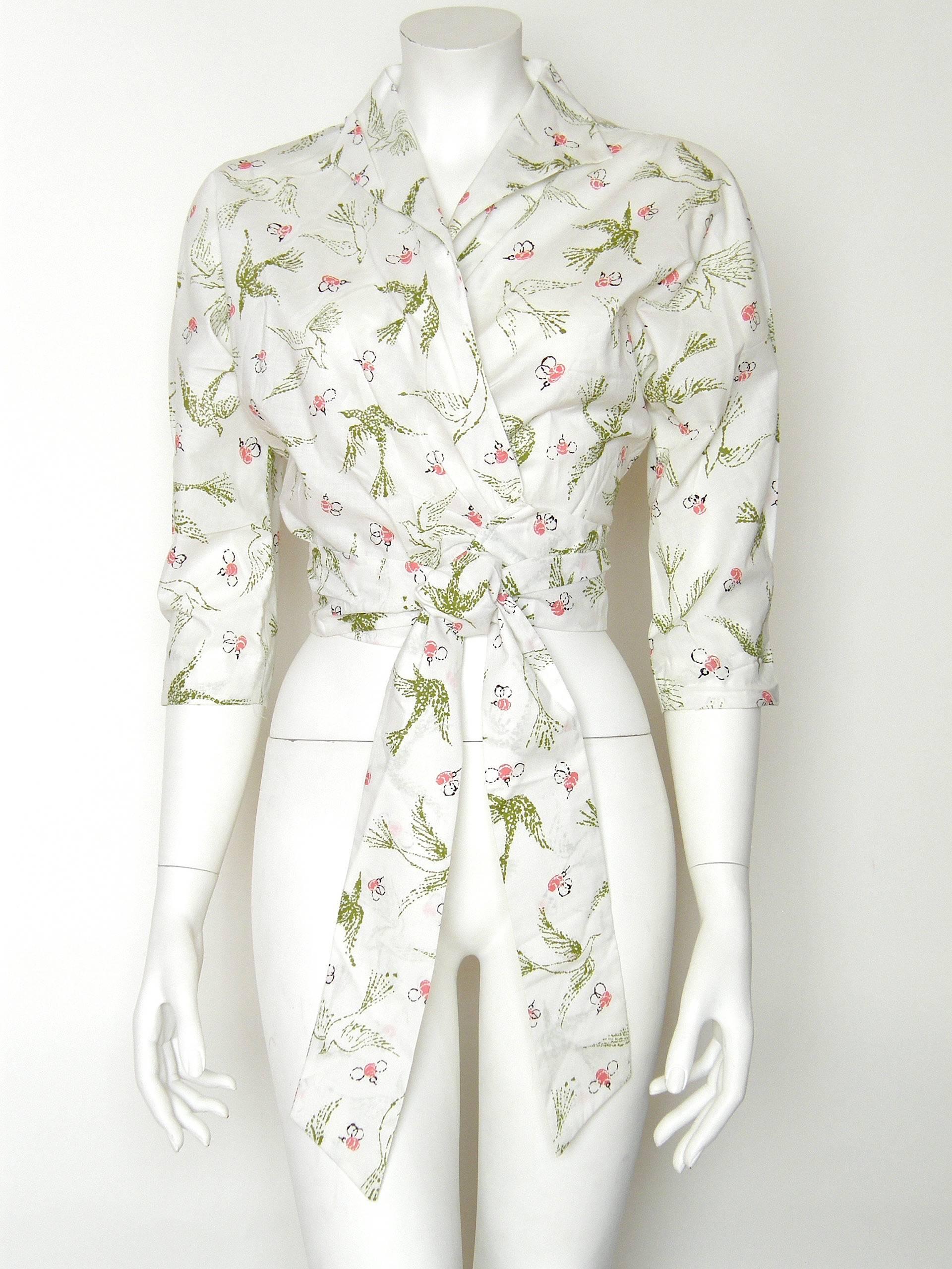 This versatile “Hug-me-tight” blouse was designed by Edith Head to promote the 1956 movie “The Birds and the Bees”, for which she designed the costumes.  The cotton novelty fabric has stylized illustrations in avocado green and azalea pink. The wrap