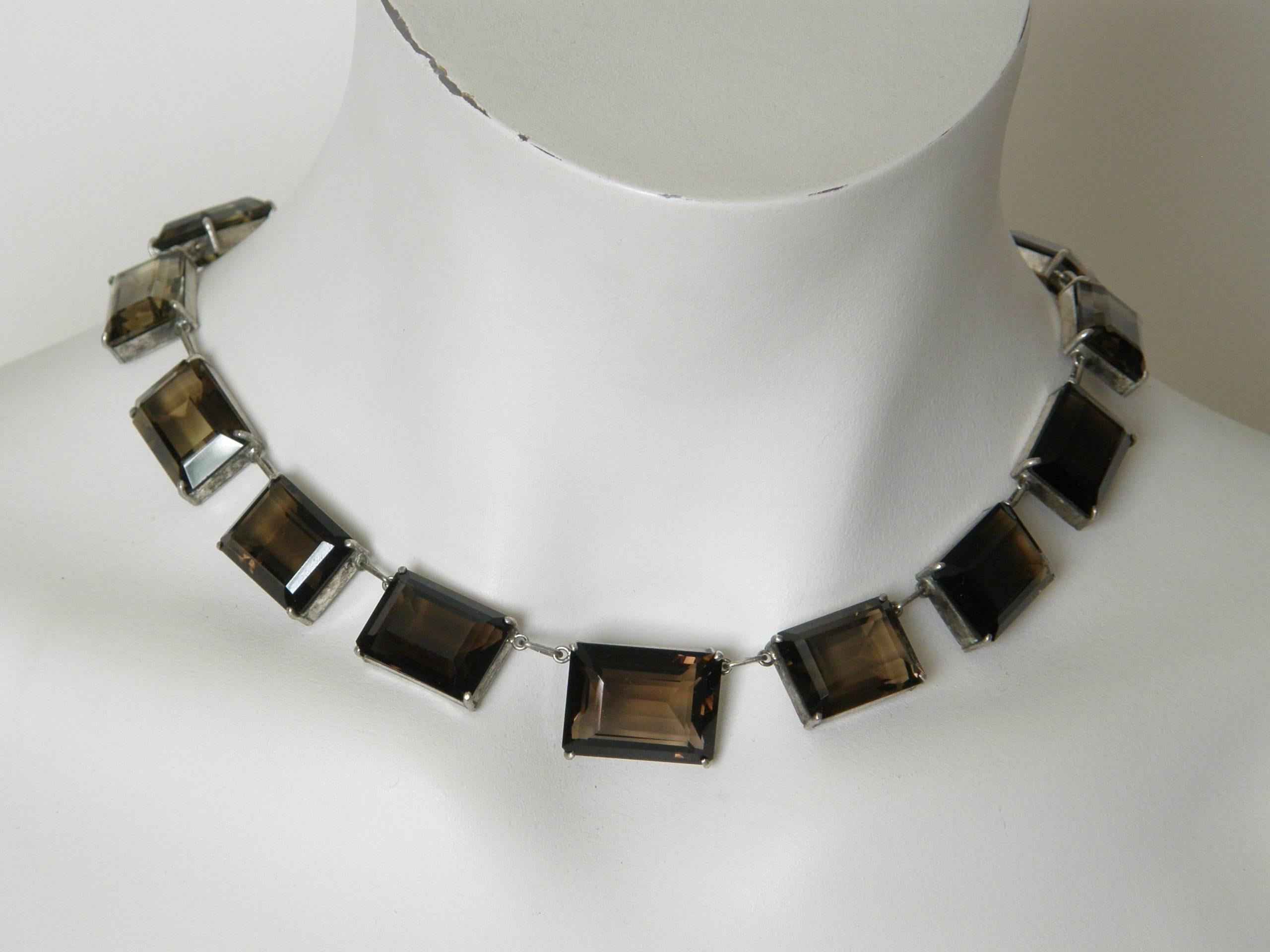 This impressive choker necklace has fifteen links with emerald cut smoky quartz set in sterling. These natural stones vary in size and also a bit in color and translucency. The clasp is marked 