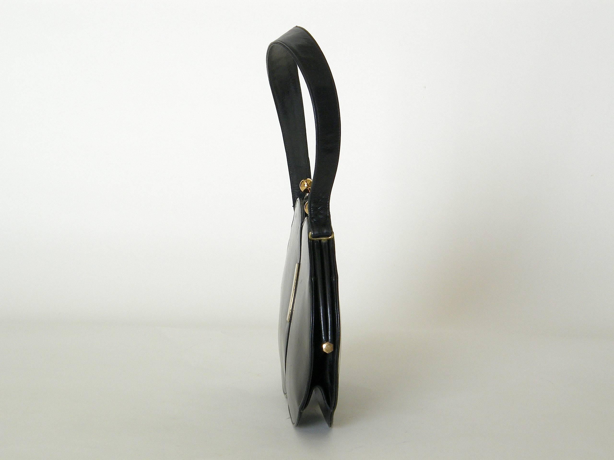 This unusual black leather handbag has an almost cartoon-like design. It looks like two overlapping bubbles with a shiny highlight on the edge of the front bubble. The kiss lock clasps are two tone with silver and gold plating. Though the bag