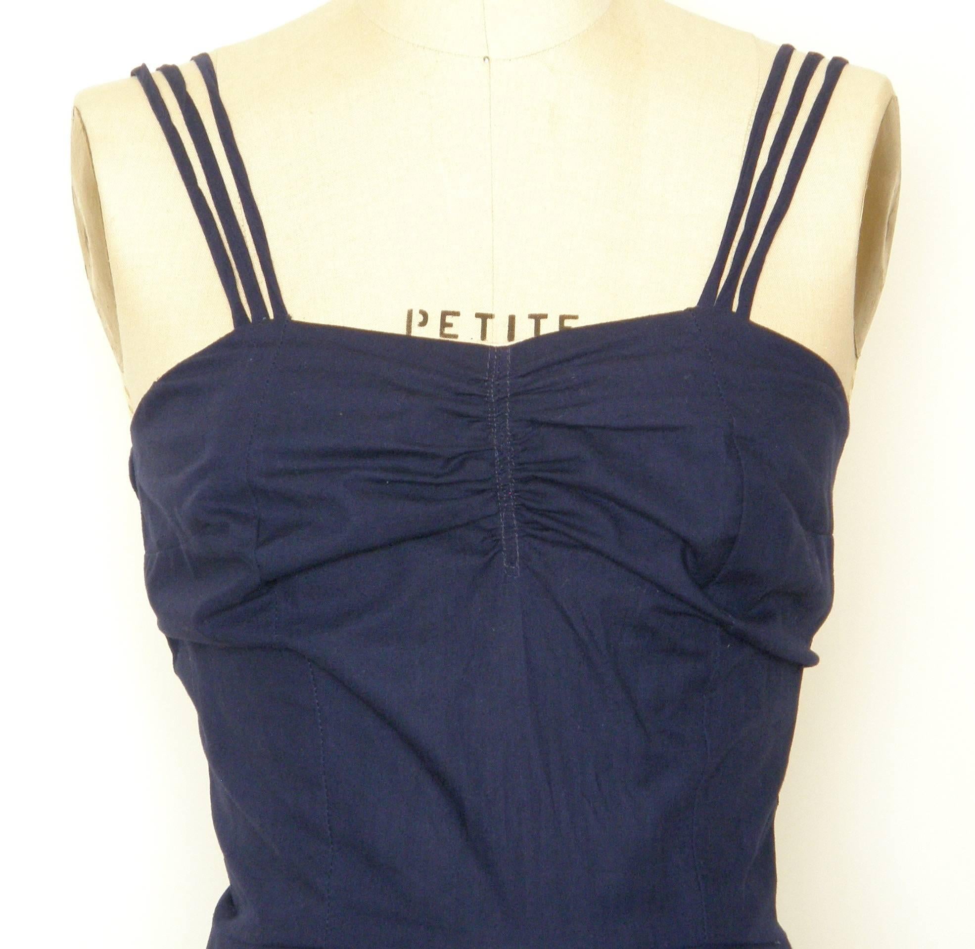 This navy blue cotton sundress was designed by Tachi Castillo and made in her workshop in Taxco, Mexico. She designed wonderful contemporary clothing inspired by classic Mexican clothing styles, and she utilized traditional techniques and shapes.