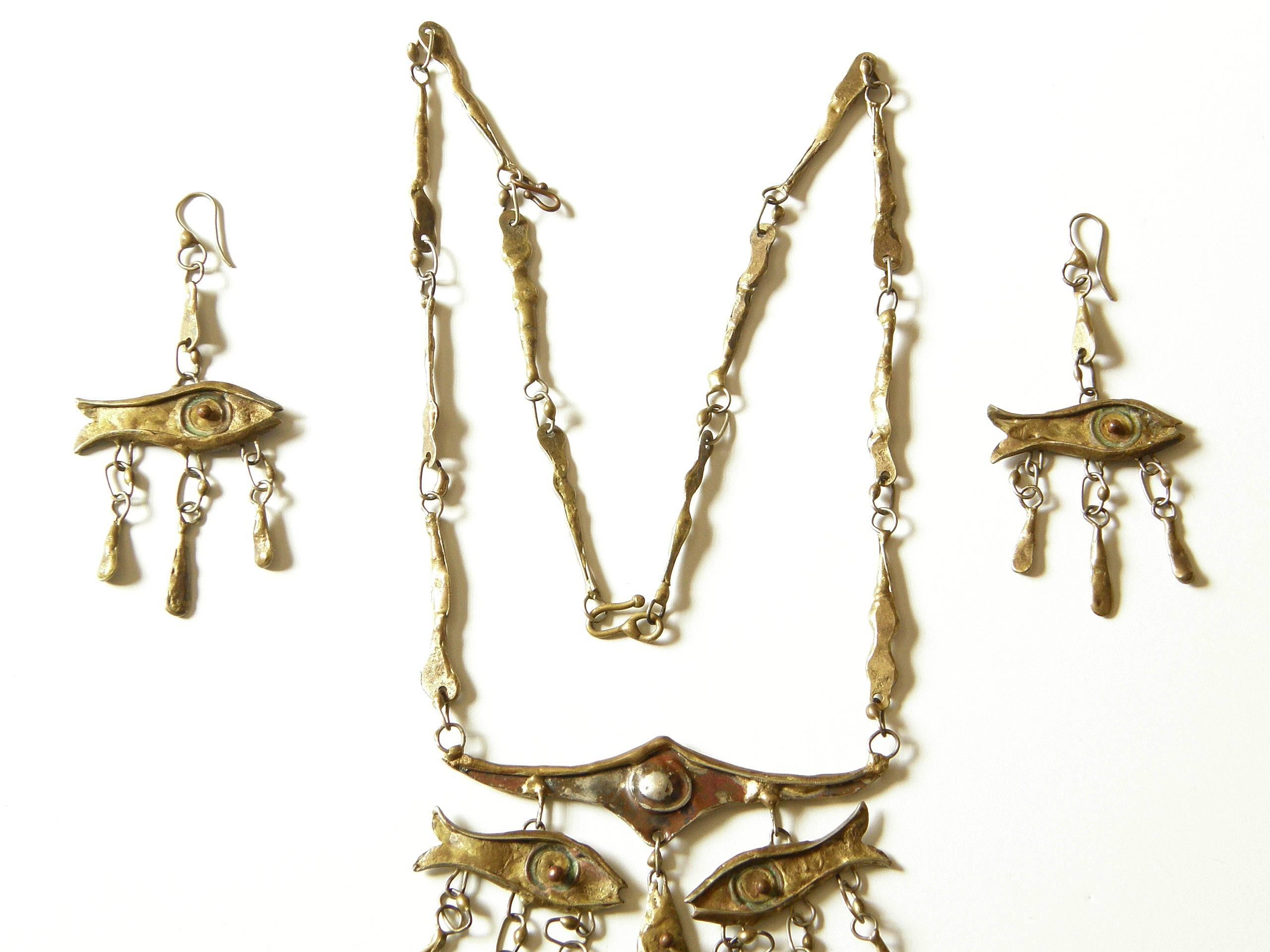 This unique necklace and earrings set was made by Mexican artist Armando Lozano Ramirez. The fish motif is utilized to great effect, creating an abstract face in the necklace. The dangling eyes and nose are fish, and a tiny puckered mouth is