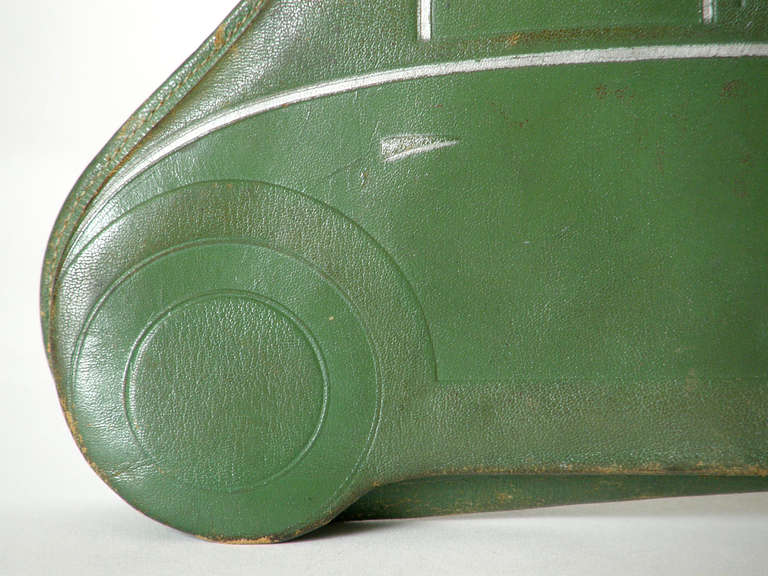 c. 1920s clutch handbag in the shape of a sporty car. The green leather body has realistic detailing impressed and painted on the front and a hand strap on the back. It has a zip top closure.

Please use Contact Dealer button if you have any