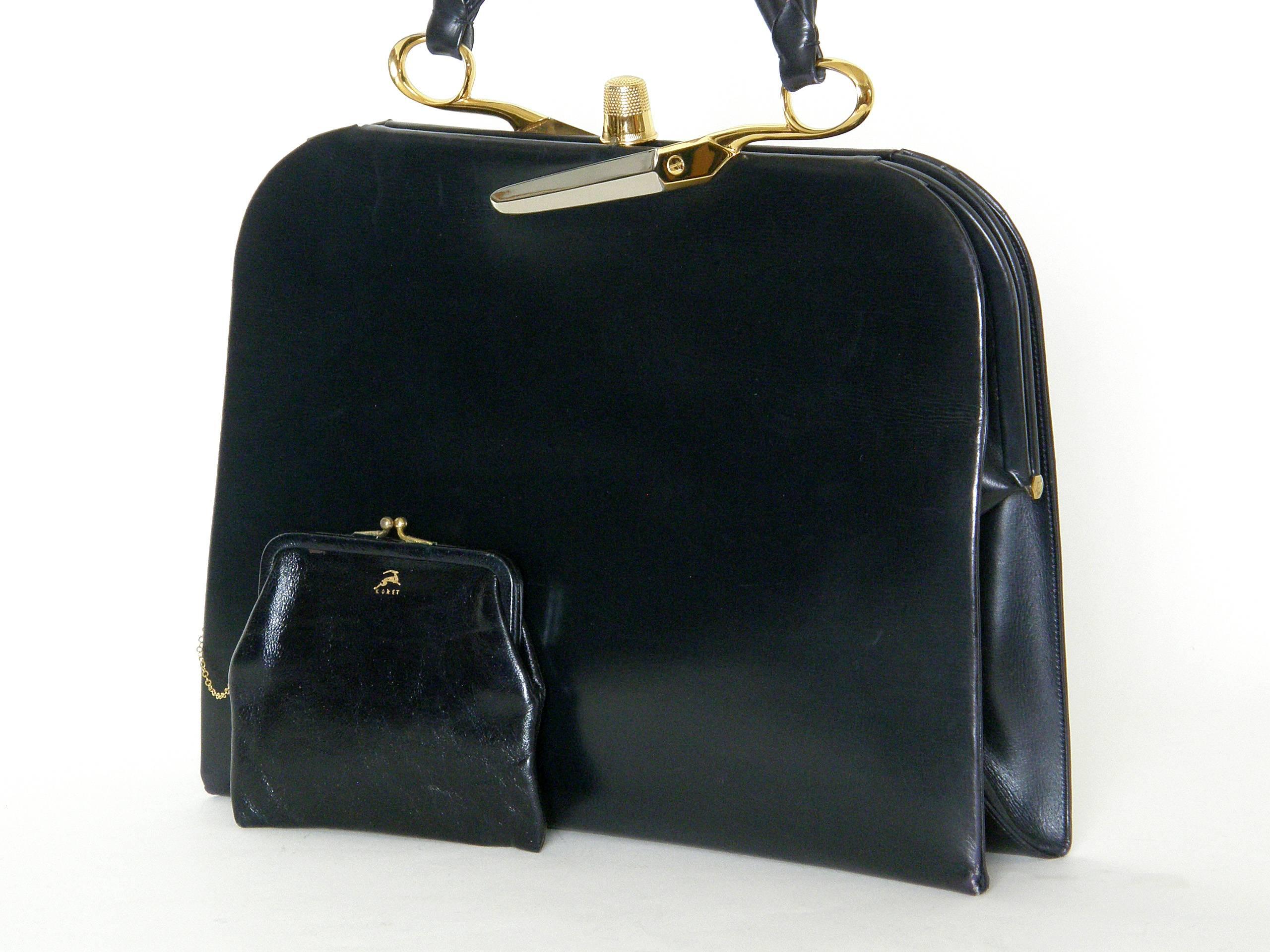 This exceptional Koret black leather handbag has dissected scissors attaching the handle to the frame and a thimble for the clasp. The yellow gold plated thimble and yellow and white gold plated scissors halves are extremely realistic. The black