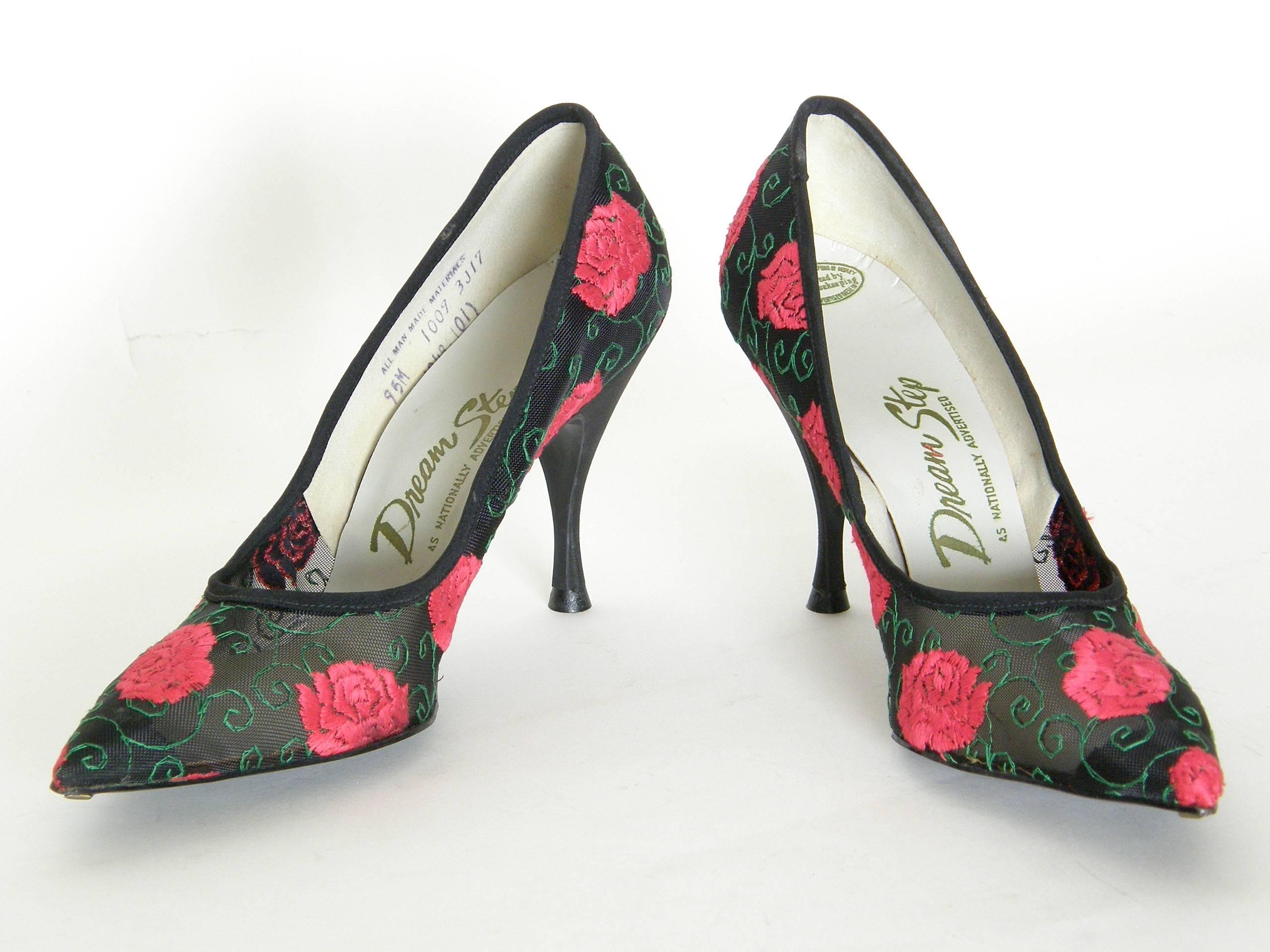 These gorgeous pumps have a classic style of the 1950s with elegant lines and pointy toes. Their shapely stiletto heels are black faille, and the body of the shoe is black mesh covered with embroidered red roses and scrolling green lines (like
