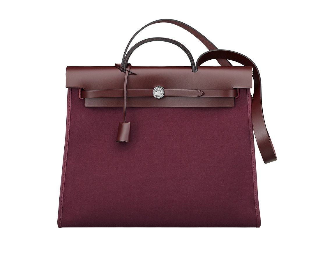 HERMES Herbag 31’ Bag in plum Officer canvas and plum Hunter cowhide, silver and palladium-plated hardware and padlock, rear zipped pocket, inside removable zipped flat pocket, handle and shoulder strap for hand or shoulder carry