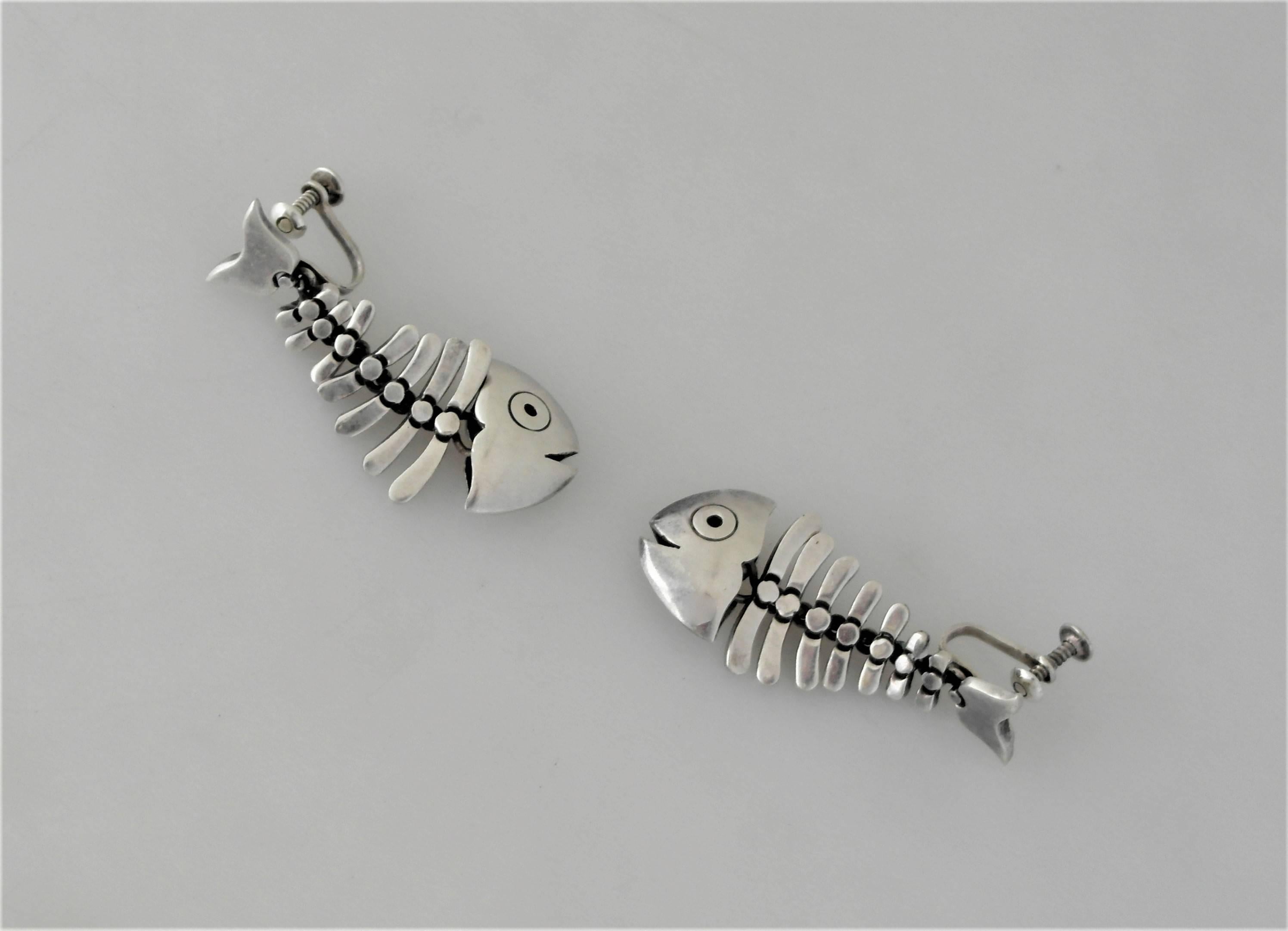 Being offered are a pair of circa 1960 sterling silver earrings made by Antonio Pineda of Taxco, Mexico. Earrings in the form of skeletal fish motifs; eagle 17 and Pineda crown mark behind the lever-back. Dimensions 1 3/4 inches long by 3/4 inches