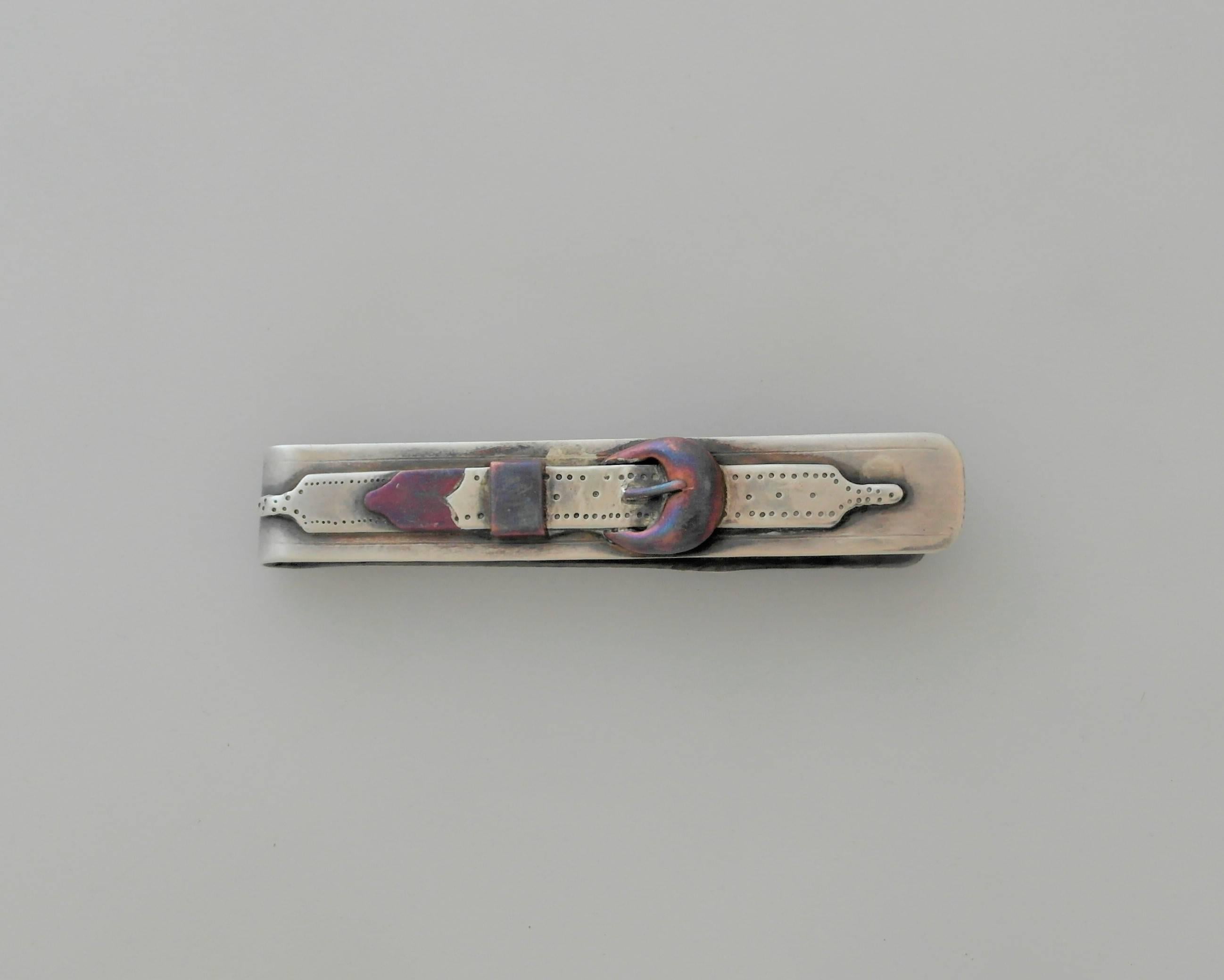 Being offered is a sterling silver money clip made by Antonio Pineda of Taxco, Mexico. Designed in the form of a belt with a copper accented belt buckle. Dimensions: 3 inches long by 1/2 inch wide. Marked as illustrated. In excellent condition.
